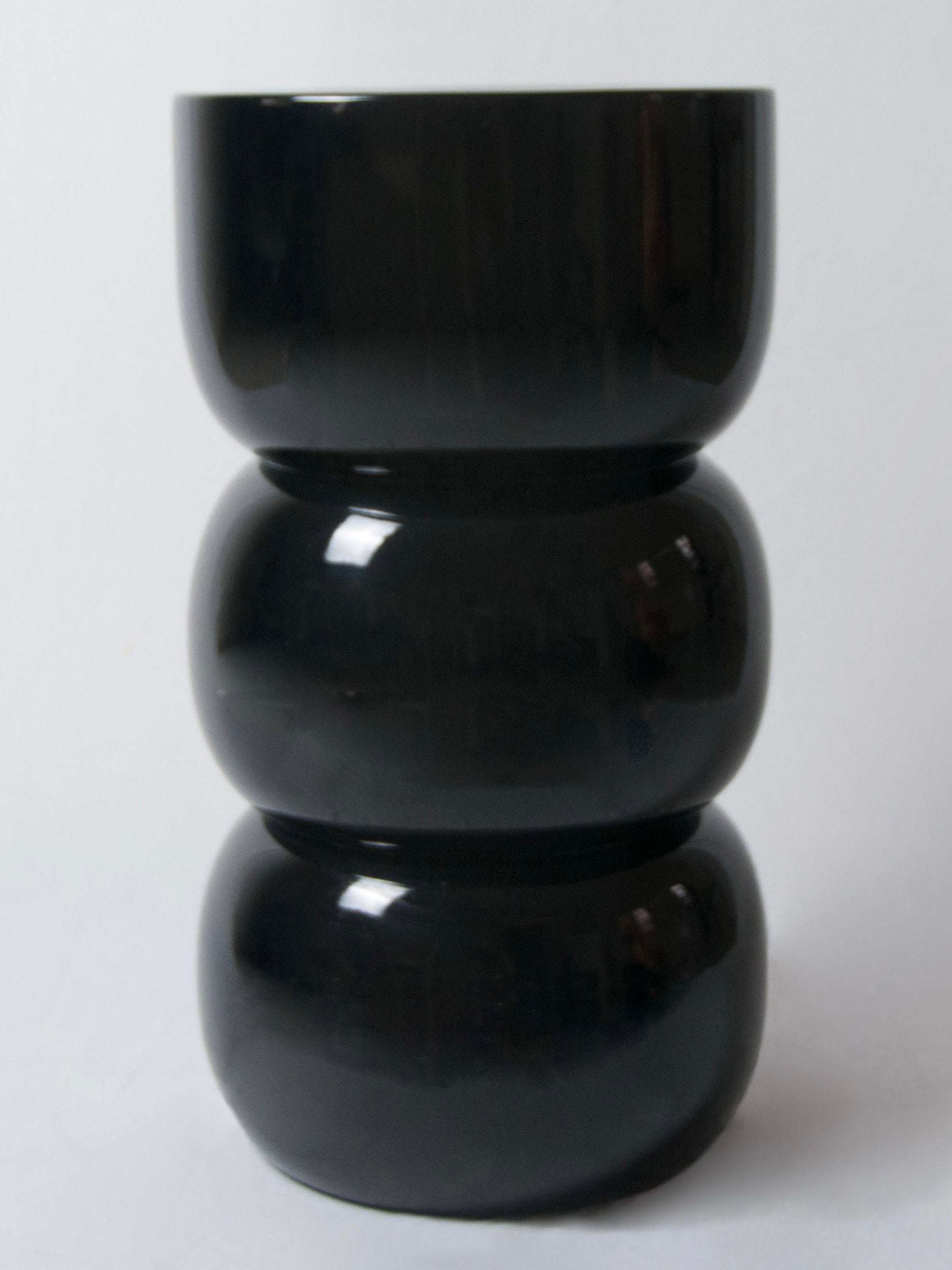 Chess' Stool convex in lacquer wood — front view of glossy black finish