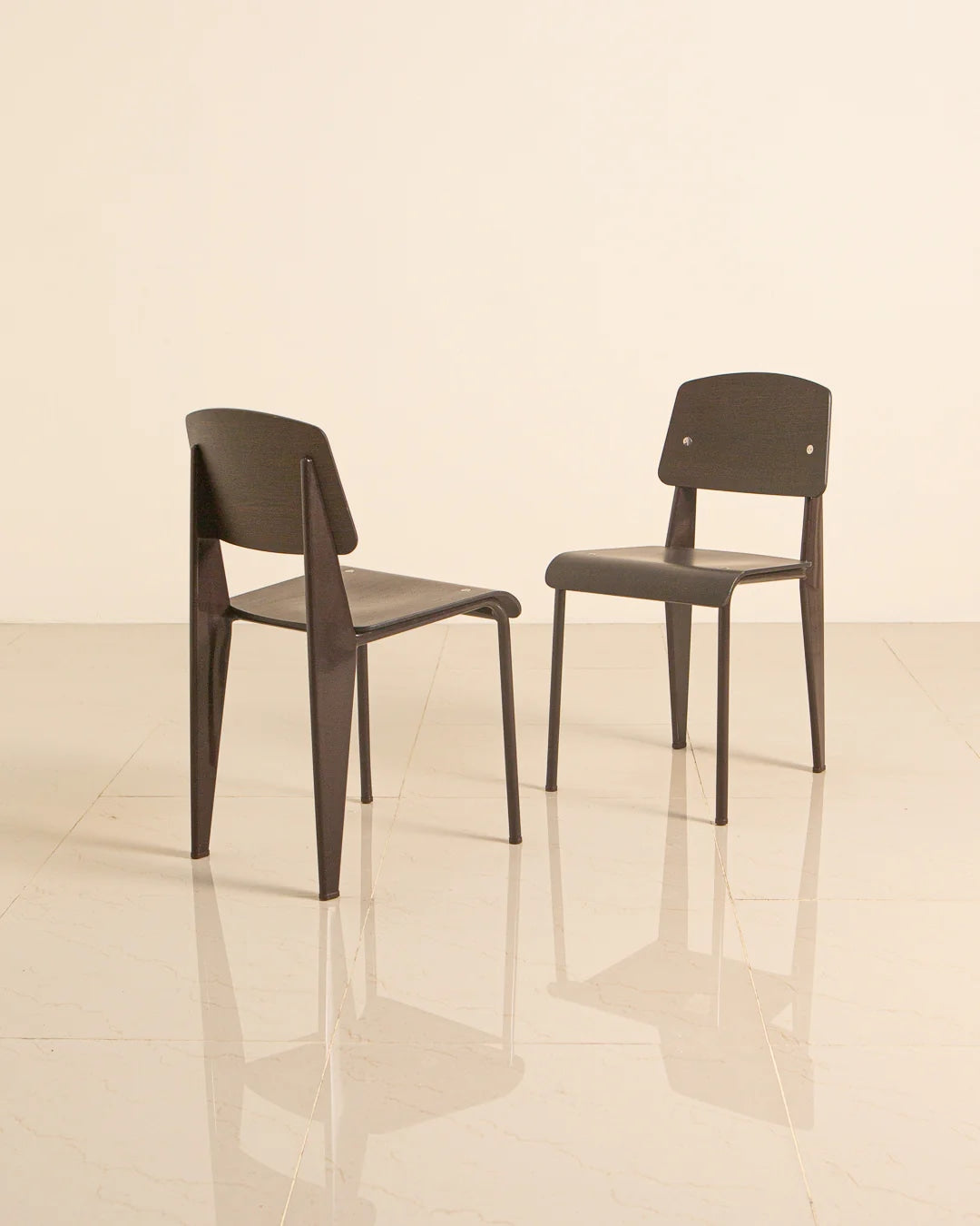 Two Jean Prouvé Standard chairs dark wood finish front angle