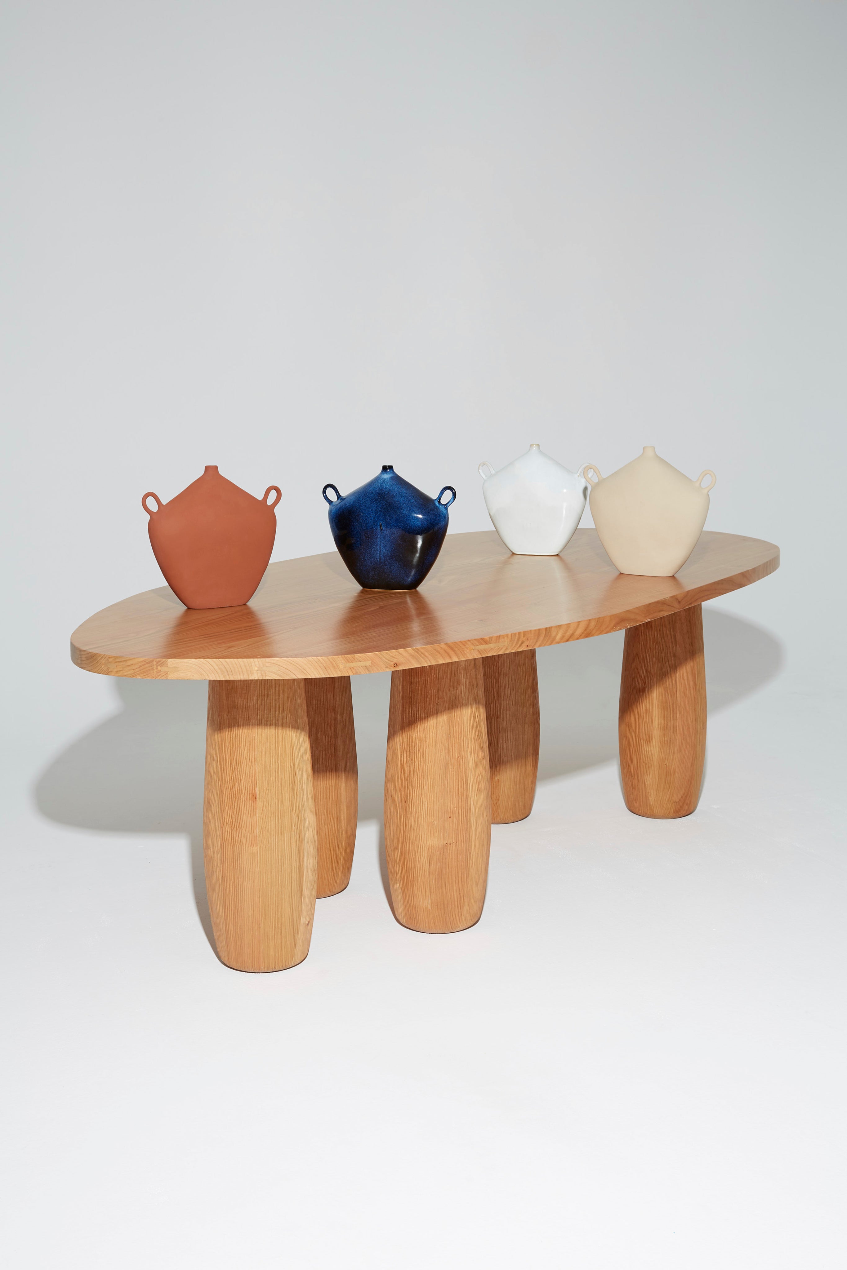 Maria Vessel - Oat — displayed on wooden table with three other vases