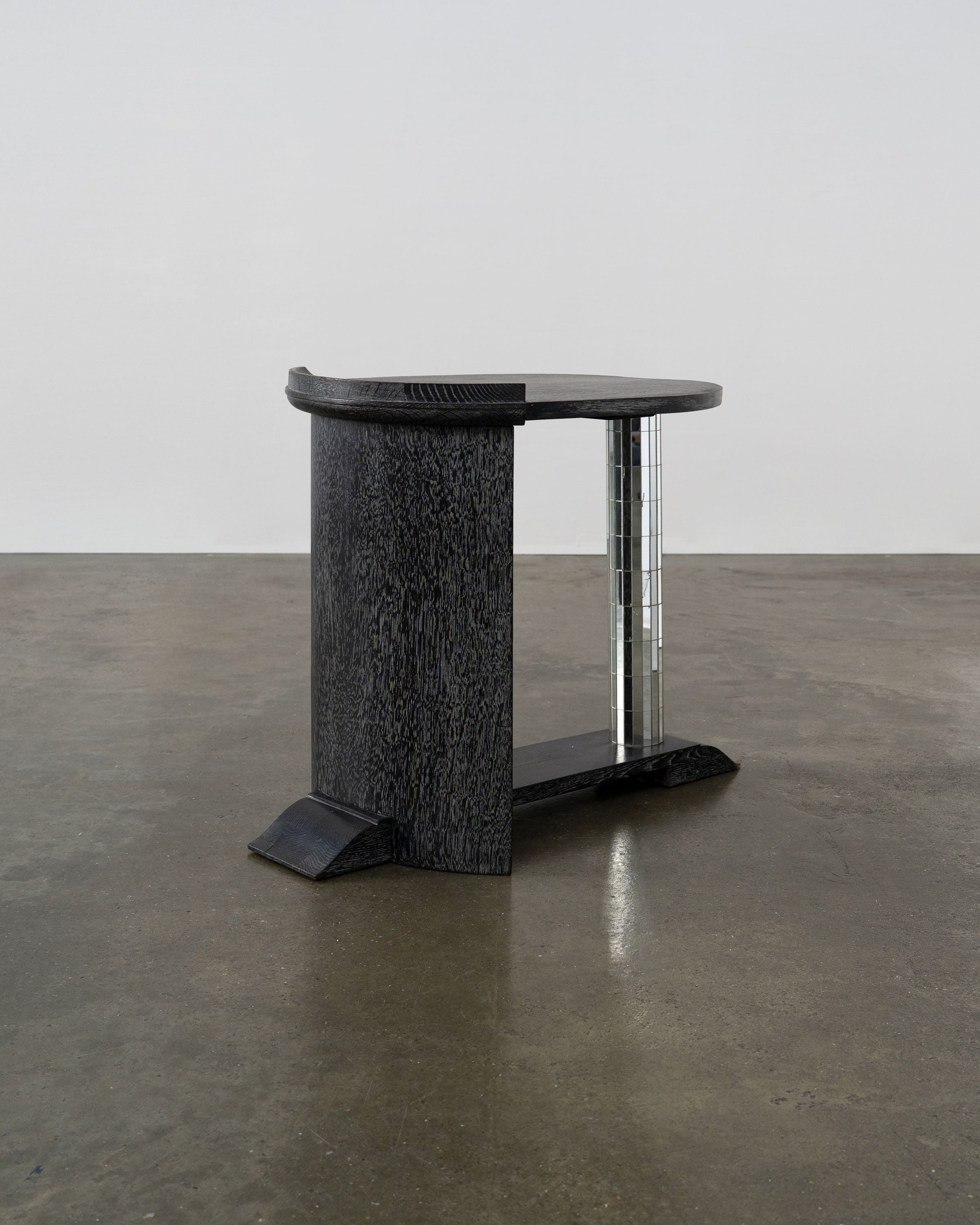Modernist Ebonised Oak and Mirror Mosaic Pedestal Table — angled view on concrete floor