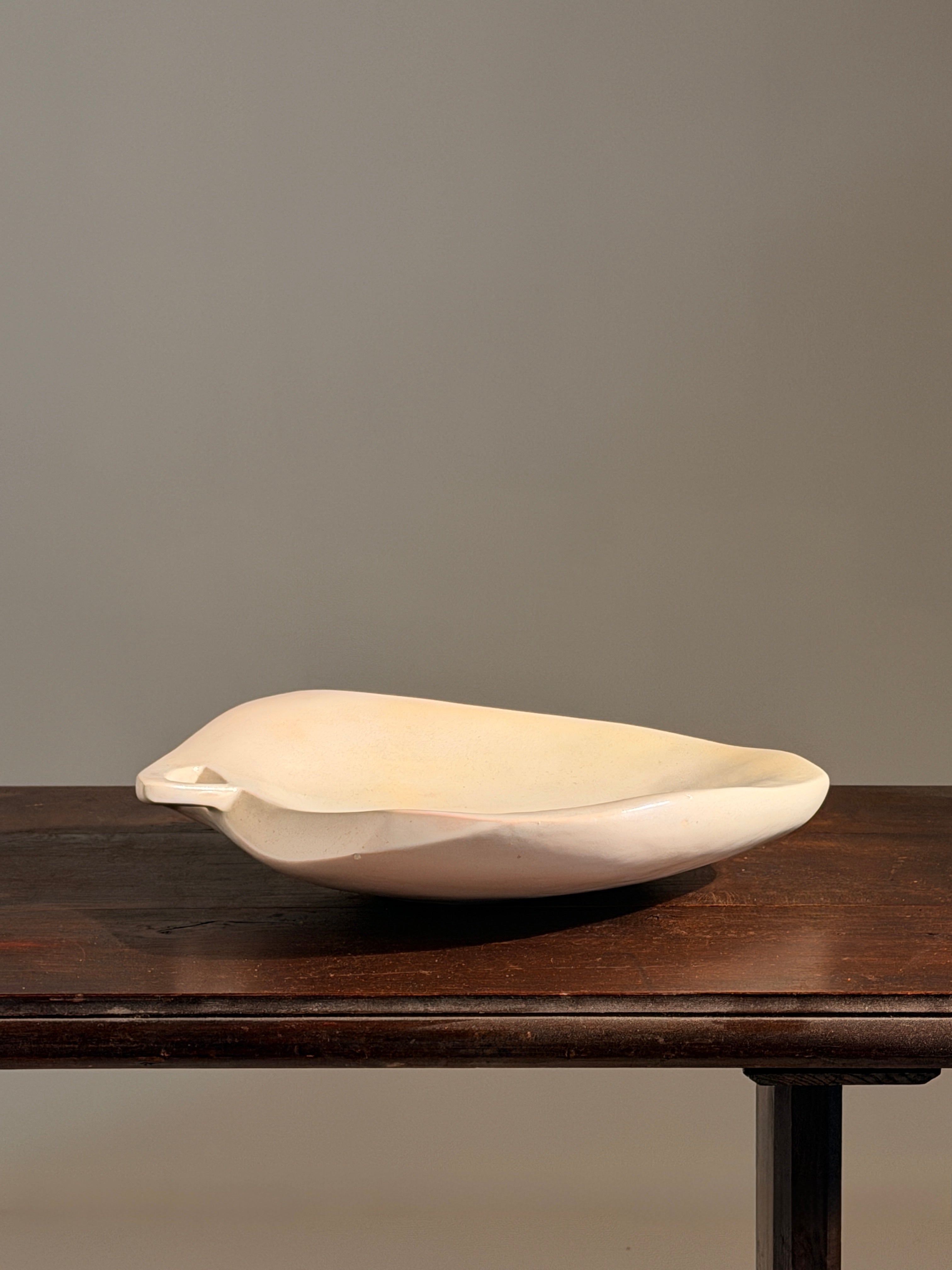 Large free-form dish in white ceramic, France, circa 1950 — side angle