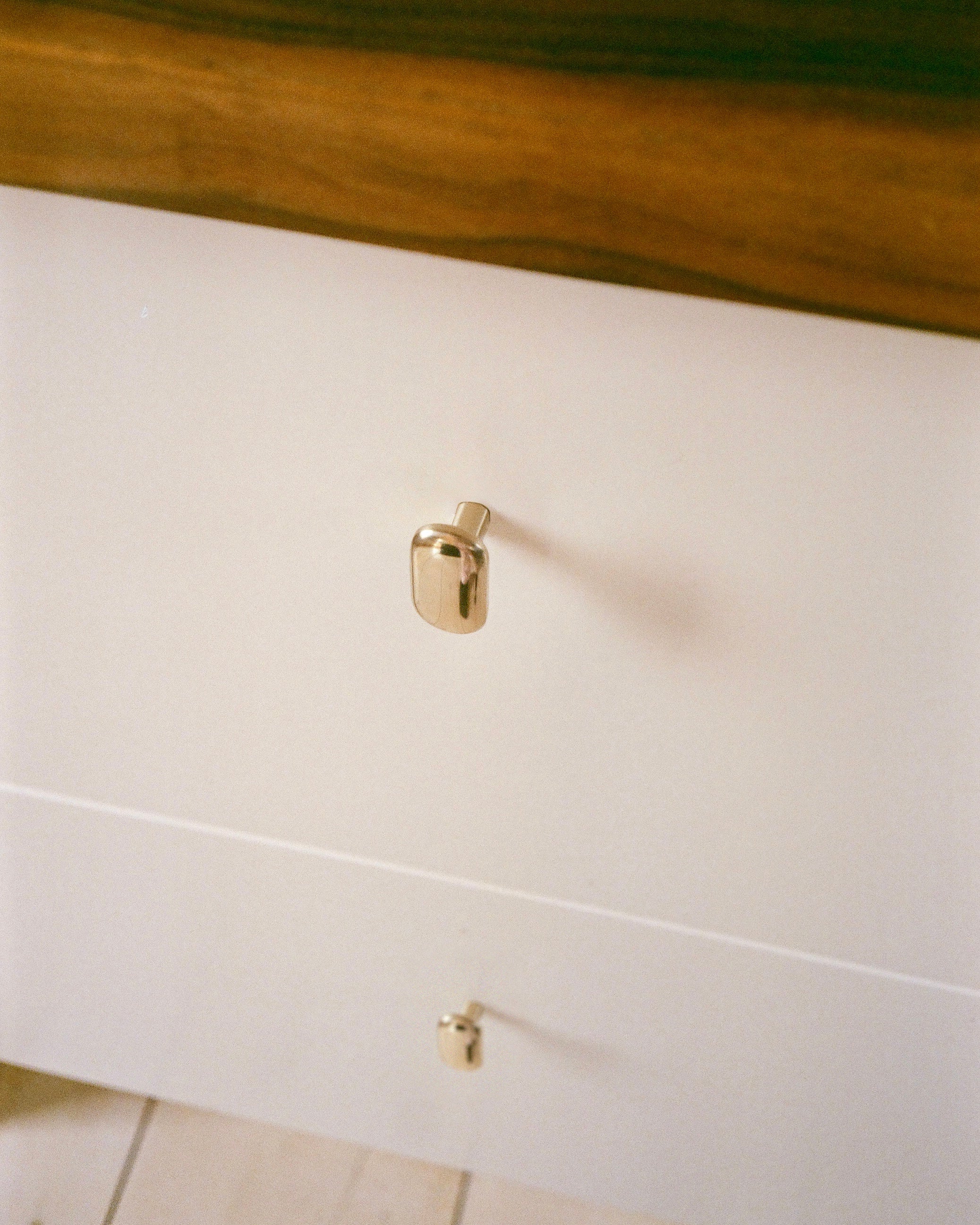 OVAL Cabinet Knob/Wall Hook — side angle showing brass finish on drawer