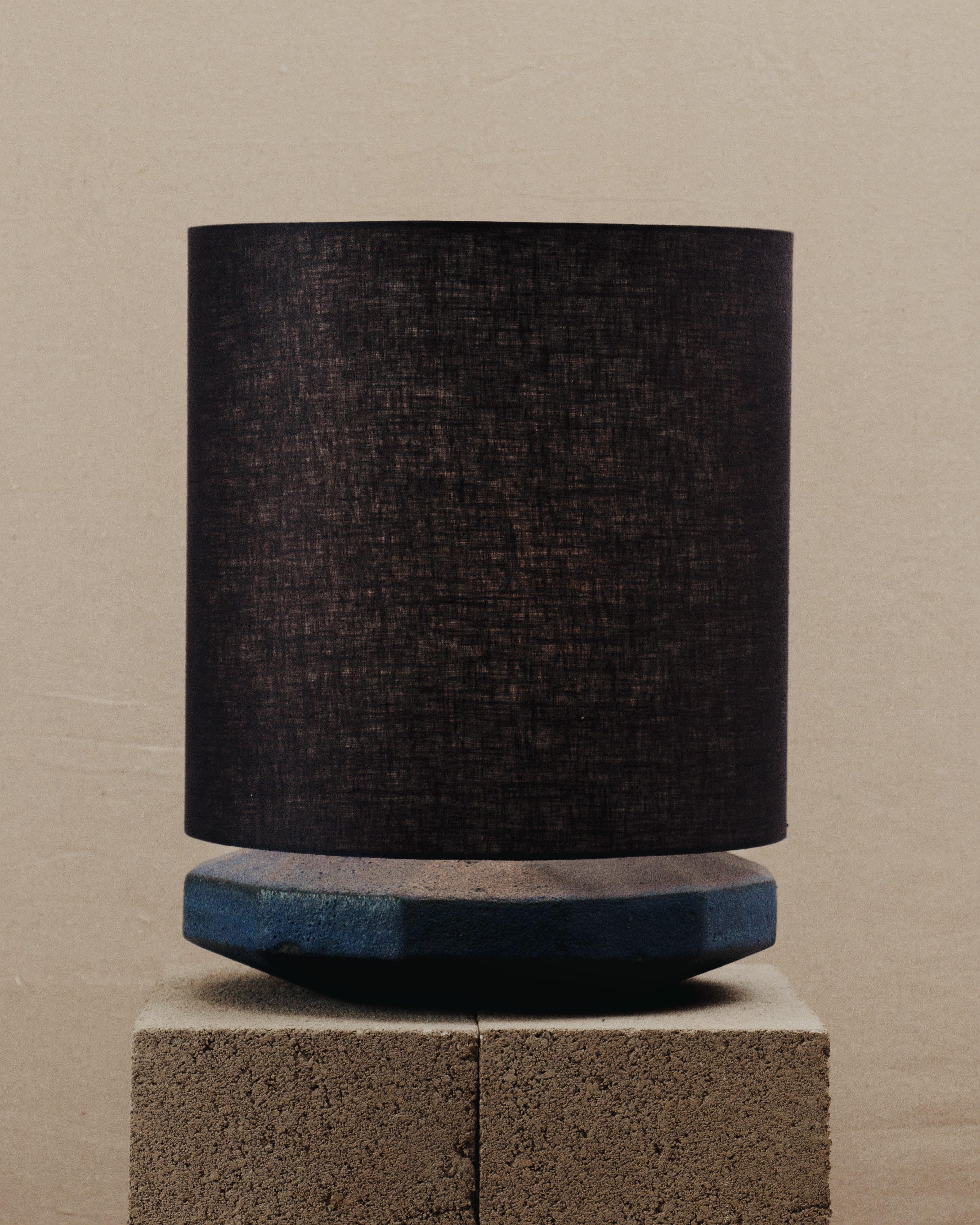 Radian Lamp — front view on textured stone pedestal