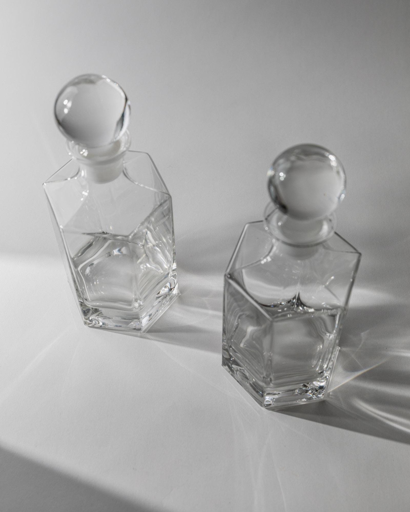 1970s Glass Decanter Set of 2 — angled view on gray surface
