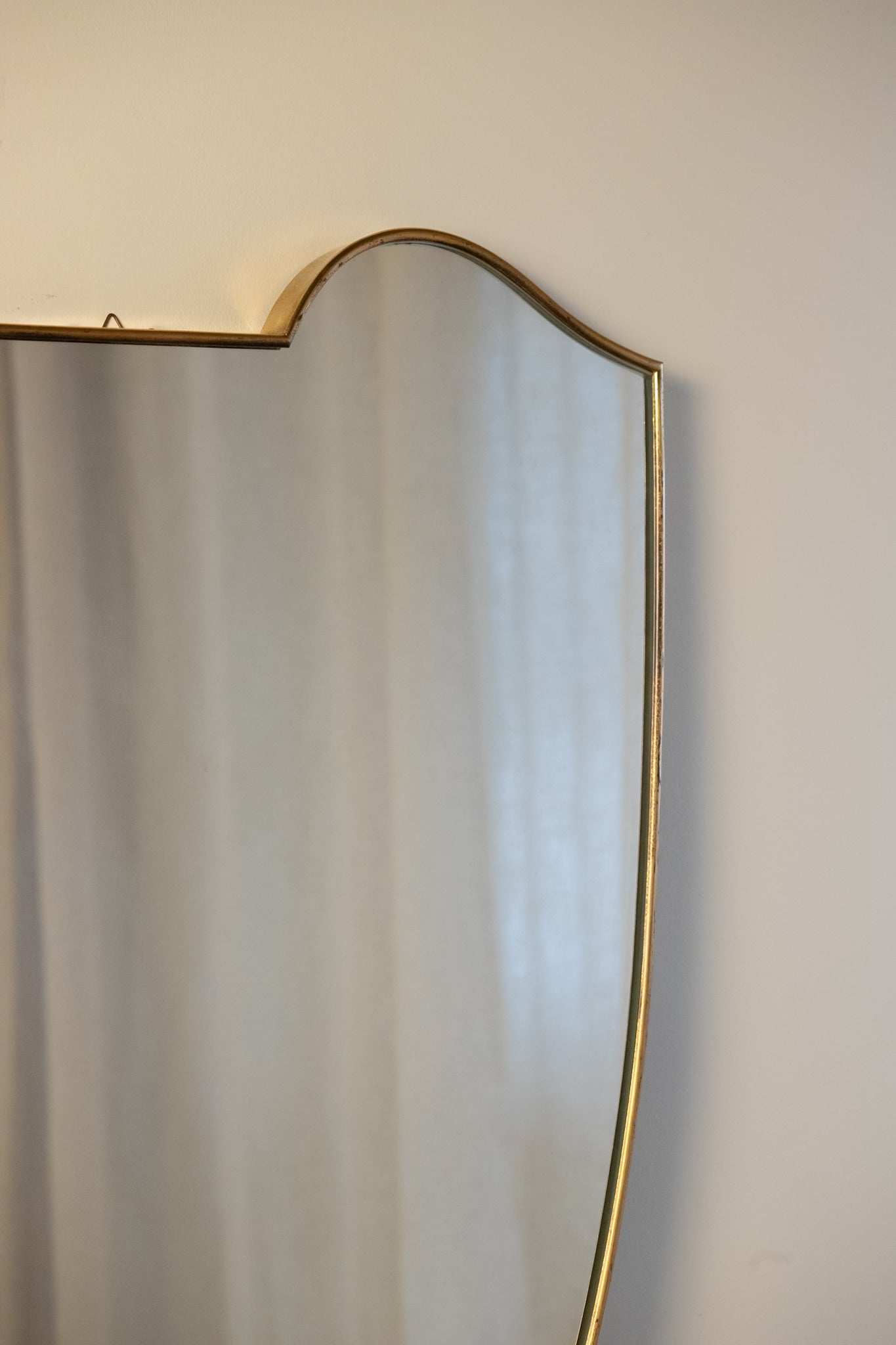 Large Midcentury Italian Brass Shield Mirror — close-up of brass edge detail