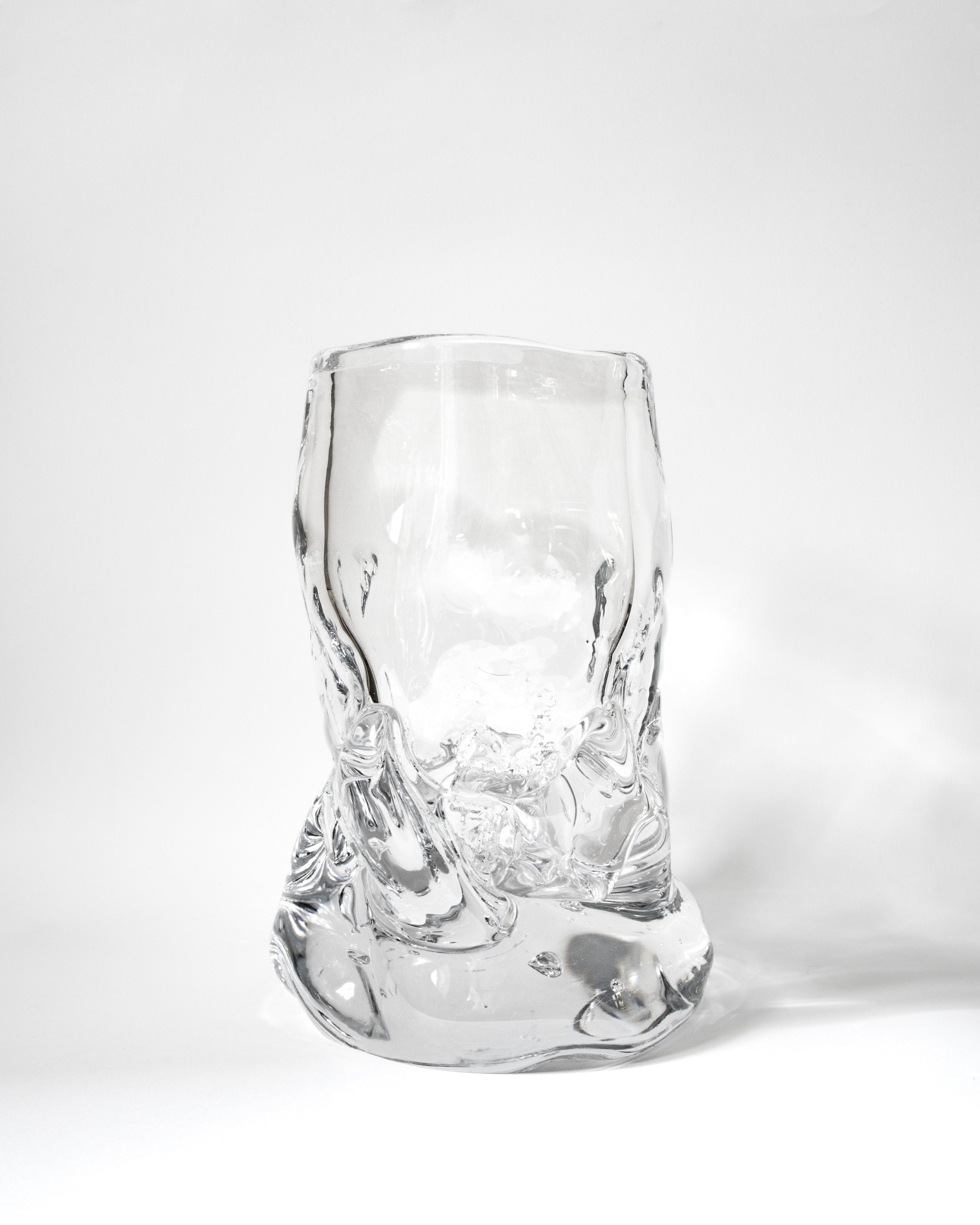 The Organically Shaped Hand-blown Vase No. 2 by Szkło Studio features an abstract, uneven design, highlighting the beauty of handcrafted glass art as it sits on a white surface against a plain white background.