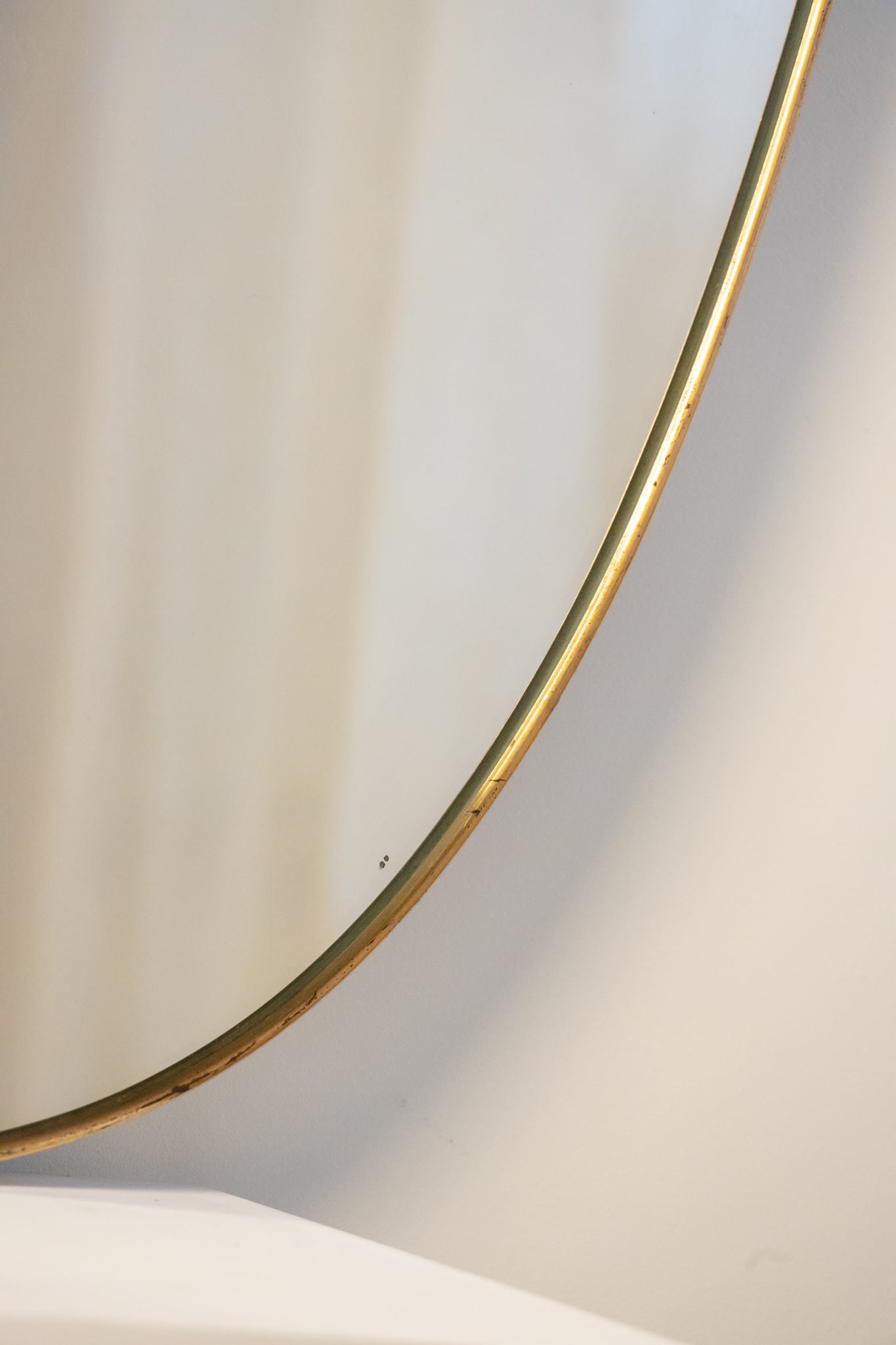 Large Midcentury Italian Brass Shield Mirror — top view of curved brass edge