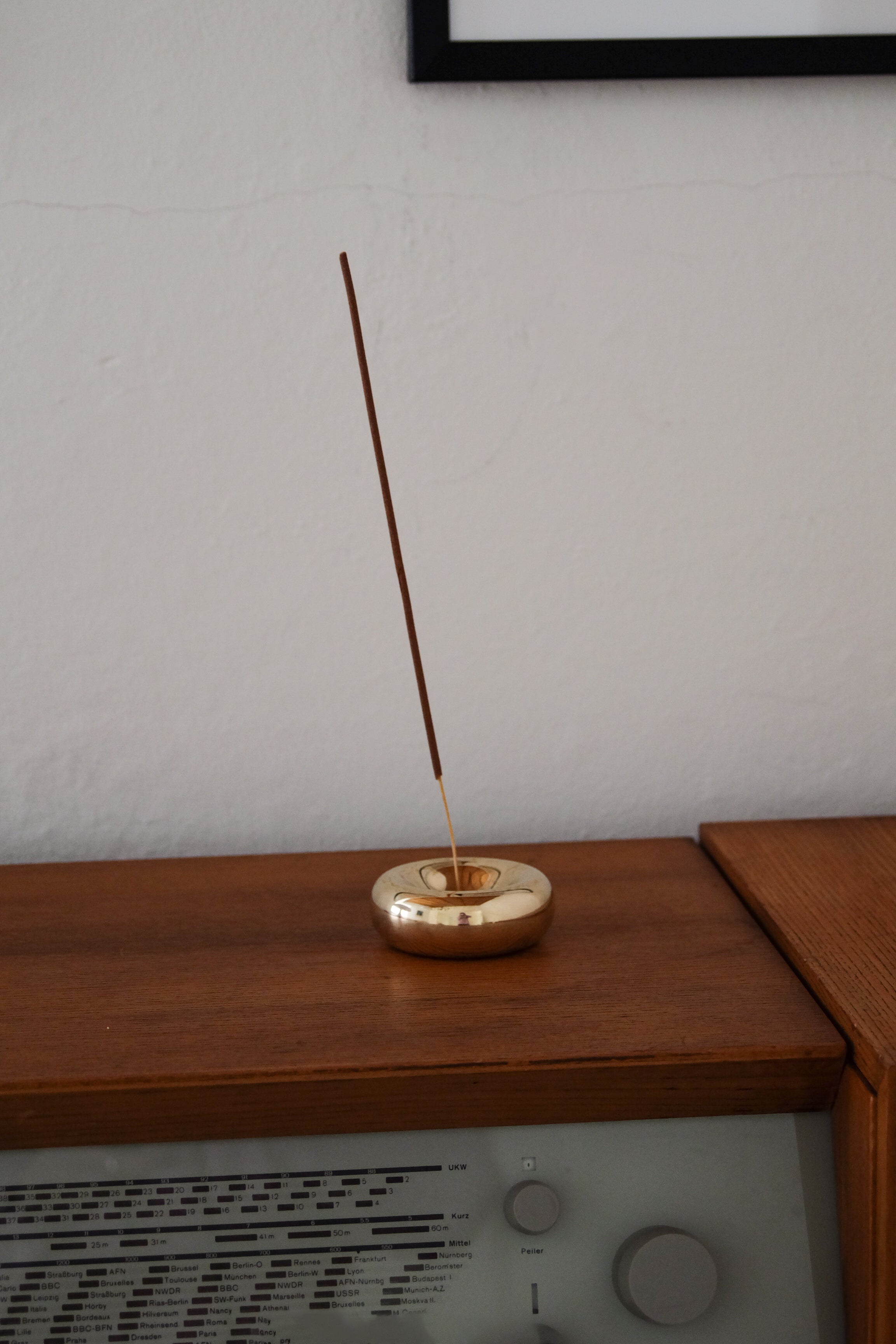 BASIN Incense Holder — close-up of polished brass on wooden surface