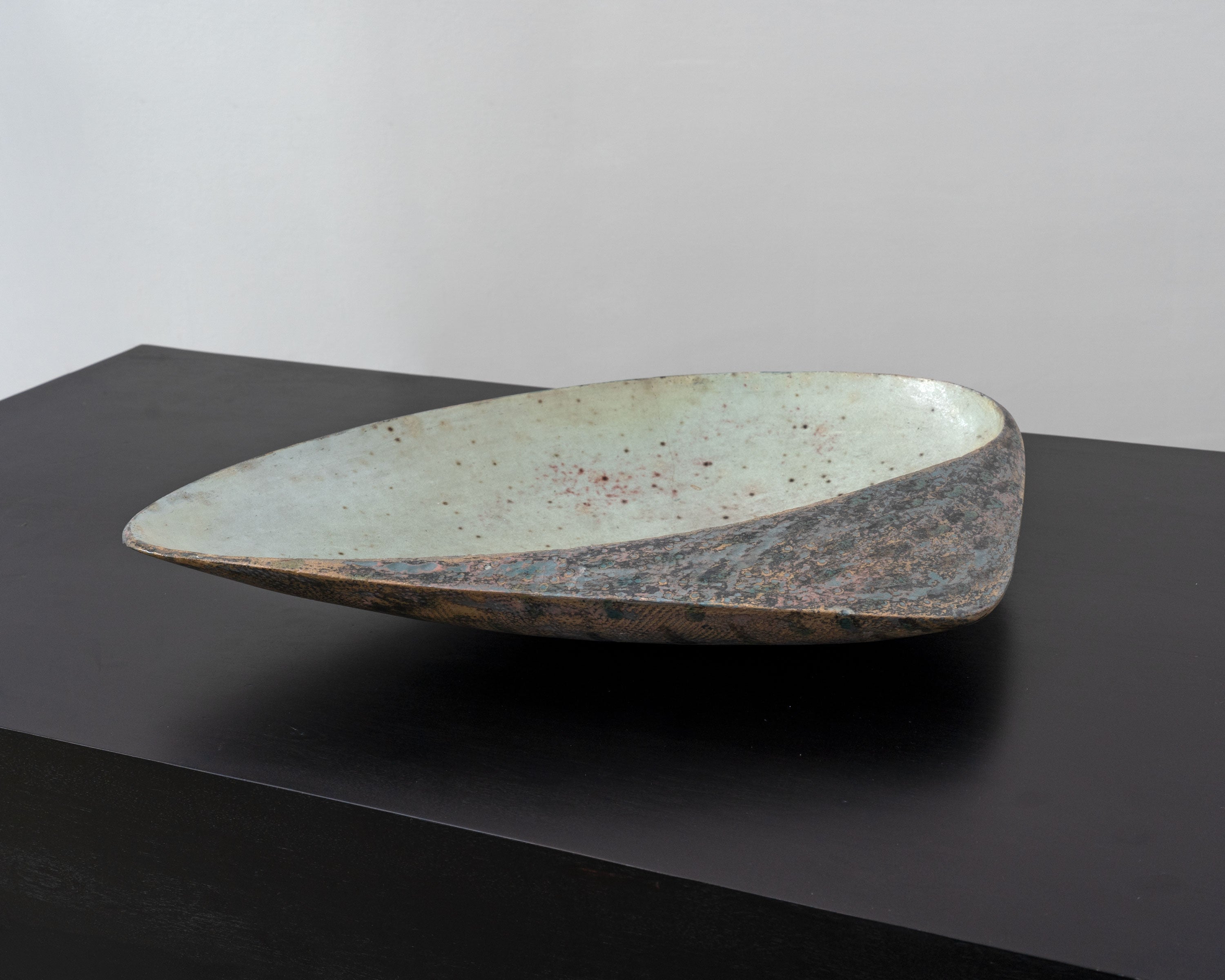Large postmodern ceramic bowl with speckled glaze, profile view