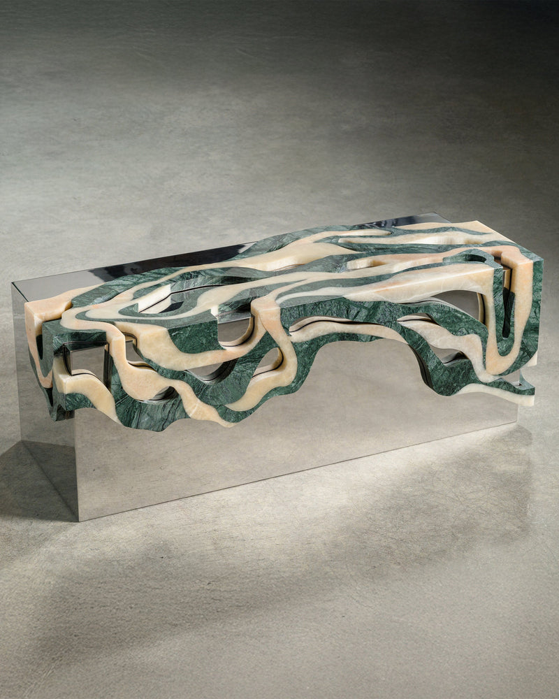 Contemporary marble bench with flowing organic cutouts in green and cream stone