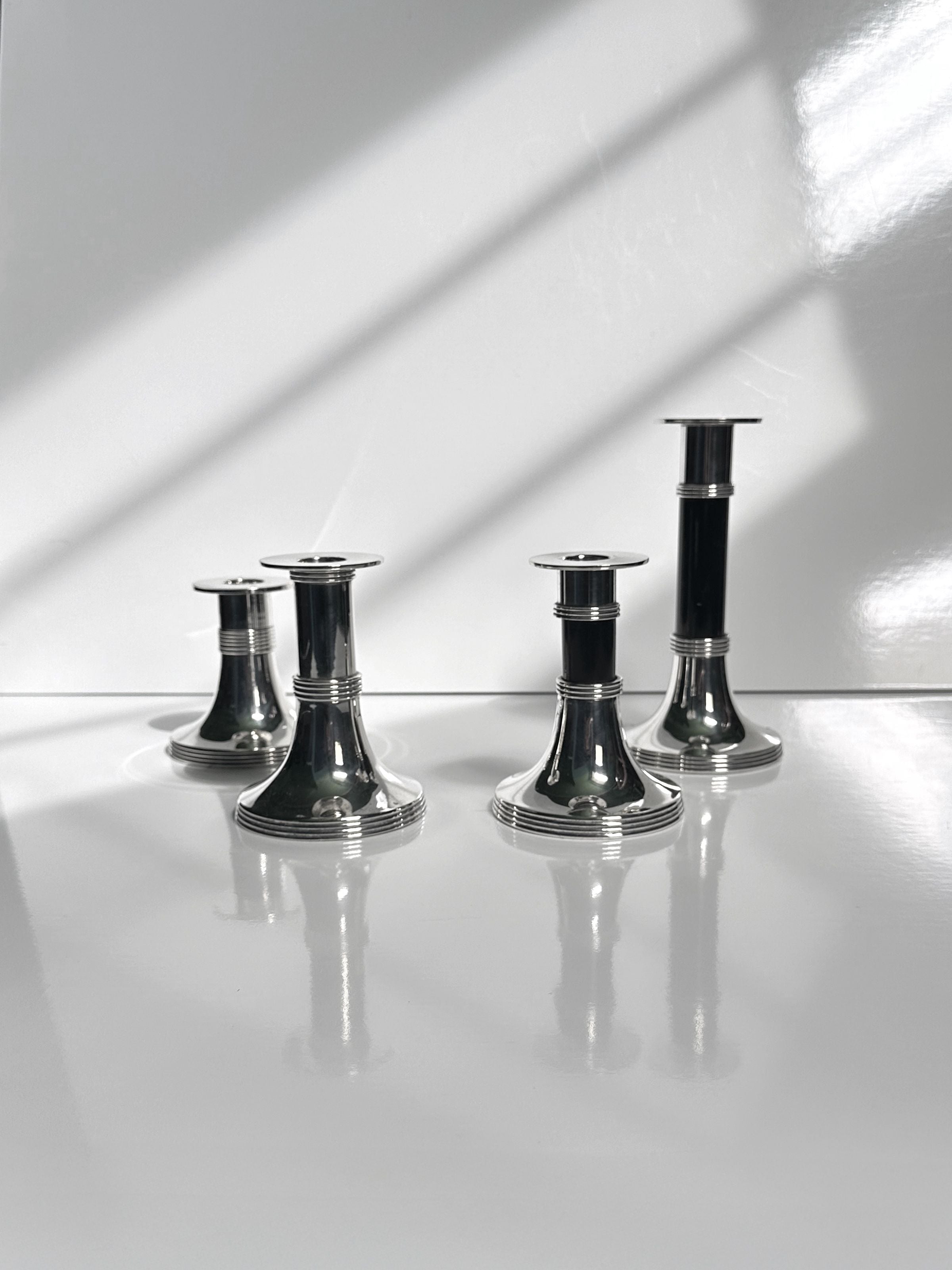 Pair of Silver Plated Candleholders by Gunther Lambert — close-up of candleholders on reflective surface