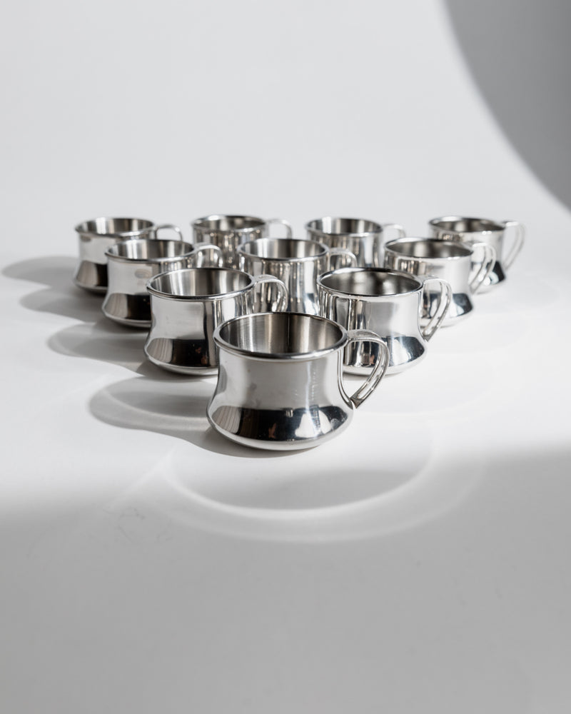 Polished stainless steel coffee cups arranged in triangular formation