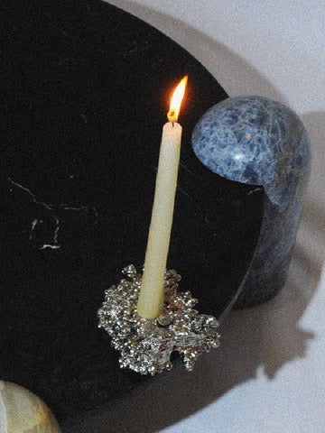 Chrome Candle Holder — close-up on silver base with lit candle