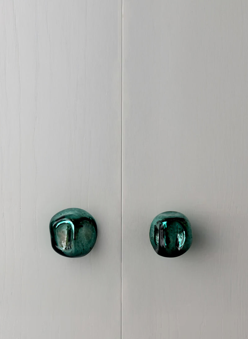 Knob Collection Sculptures in Glass — close-up of green glass knobs on cabinet