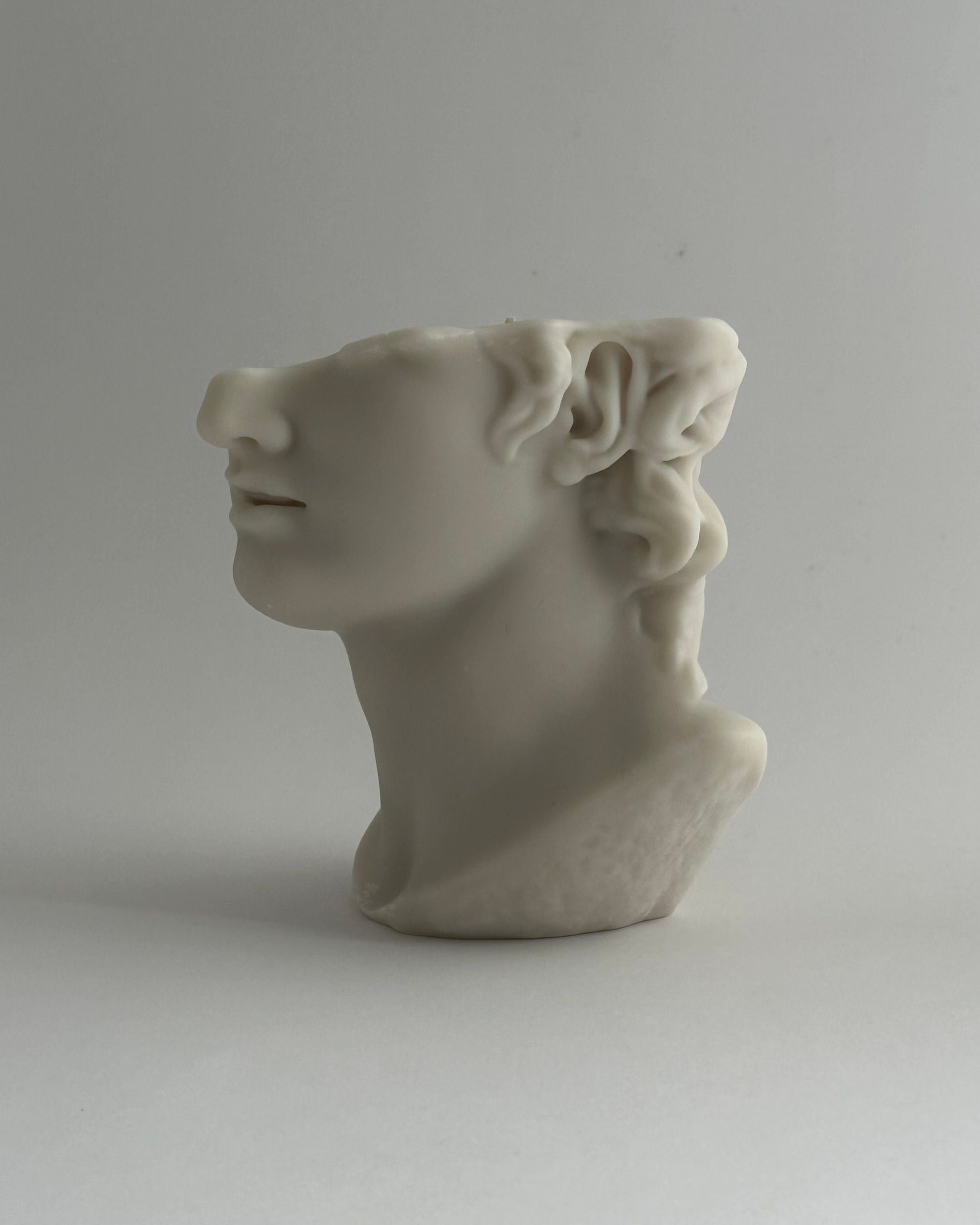 THE GREAT' candle — side view of white ceramic head sculpture