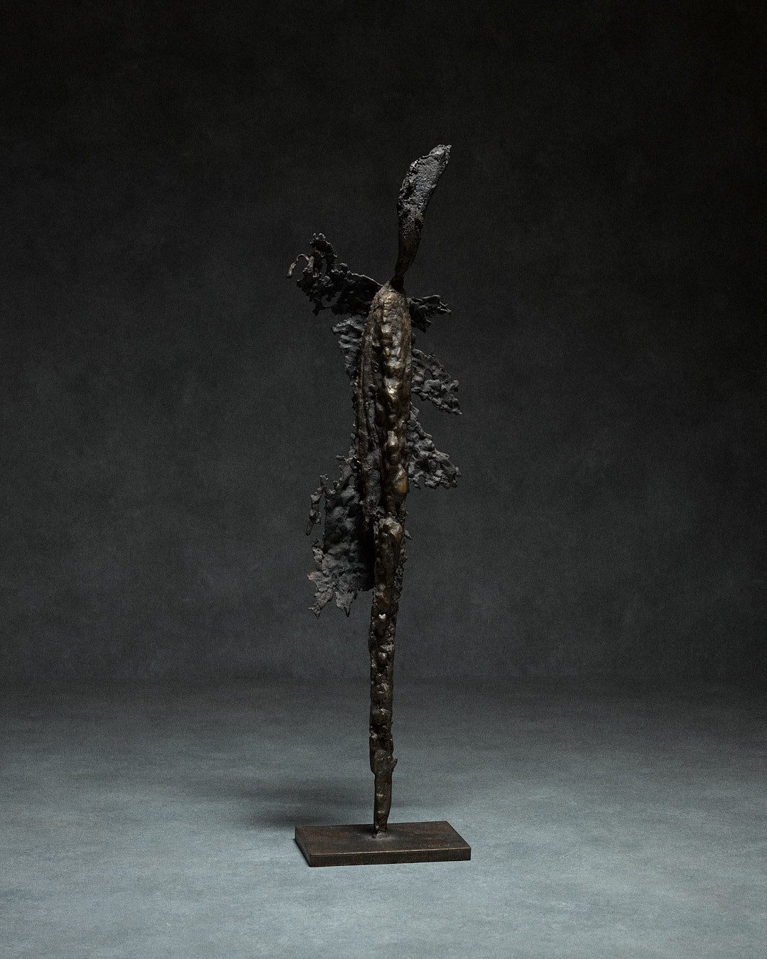 Skeletal Sculpture in Iron by Francois Saison — back view against dark background