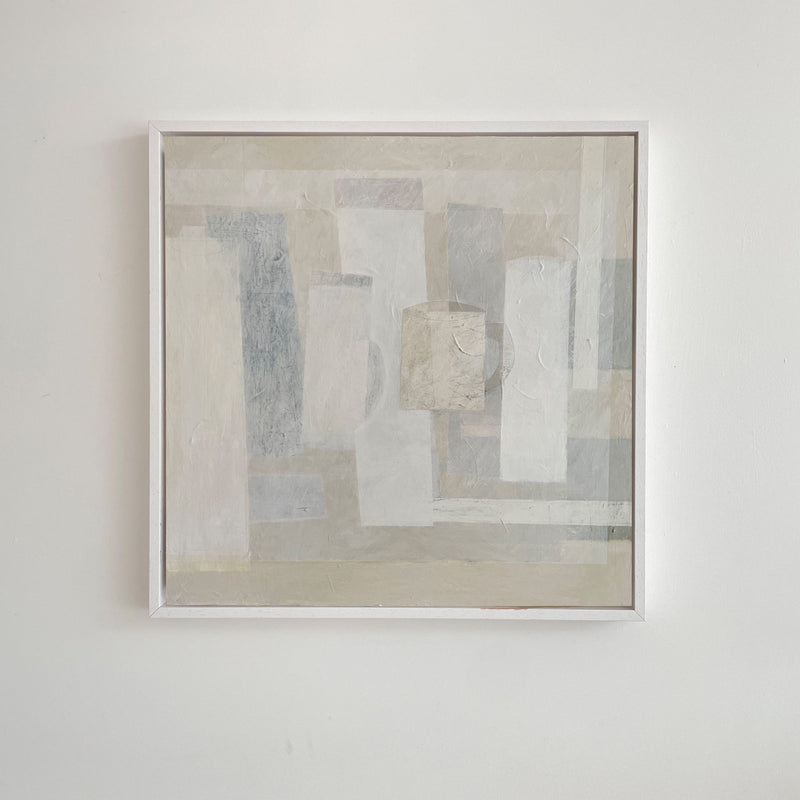 The "Every Shade Of Pale" framed abstract painting by Lara Voce features sculptural rectangles in muted gray, white, and beige. Its overlapping geometric forms enhance depth and subtle texture, adding elegance to a minimalist interior against a plain white wall—ideal for a luxury aesthetic.