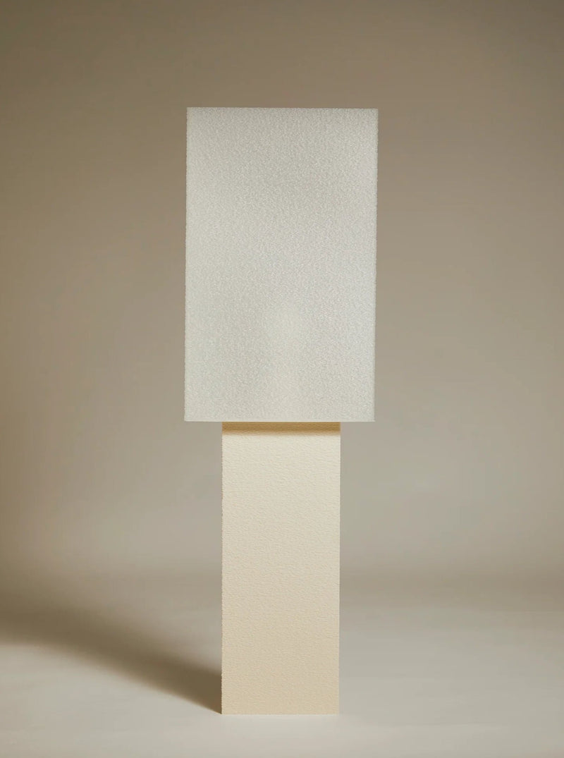 Two Lampe ii rectangular blocks stacked vertically, with a smooth, light-colored texture against a soft beige background, creating a minimalistic composition inspired by minimalist Japanese design.