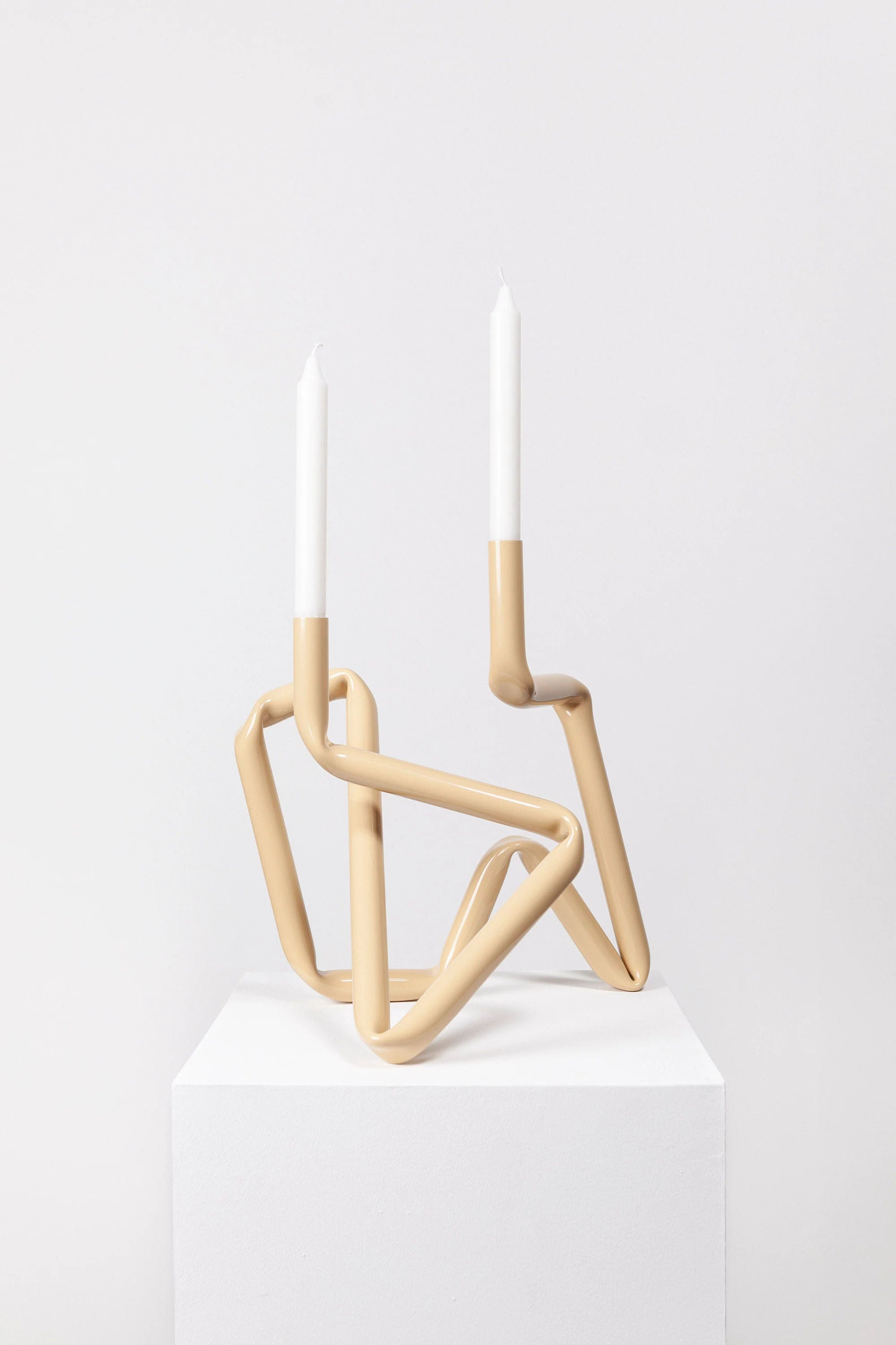 A beige Bucati candle holder, a stylish and modern home decor accessory