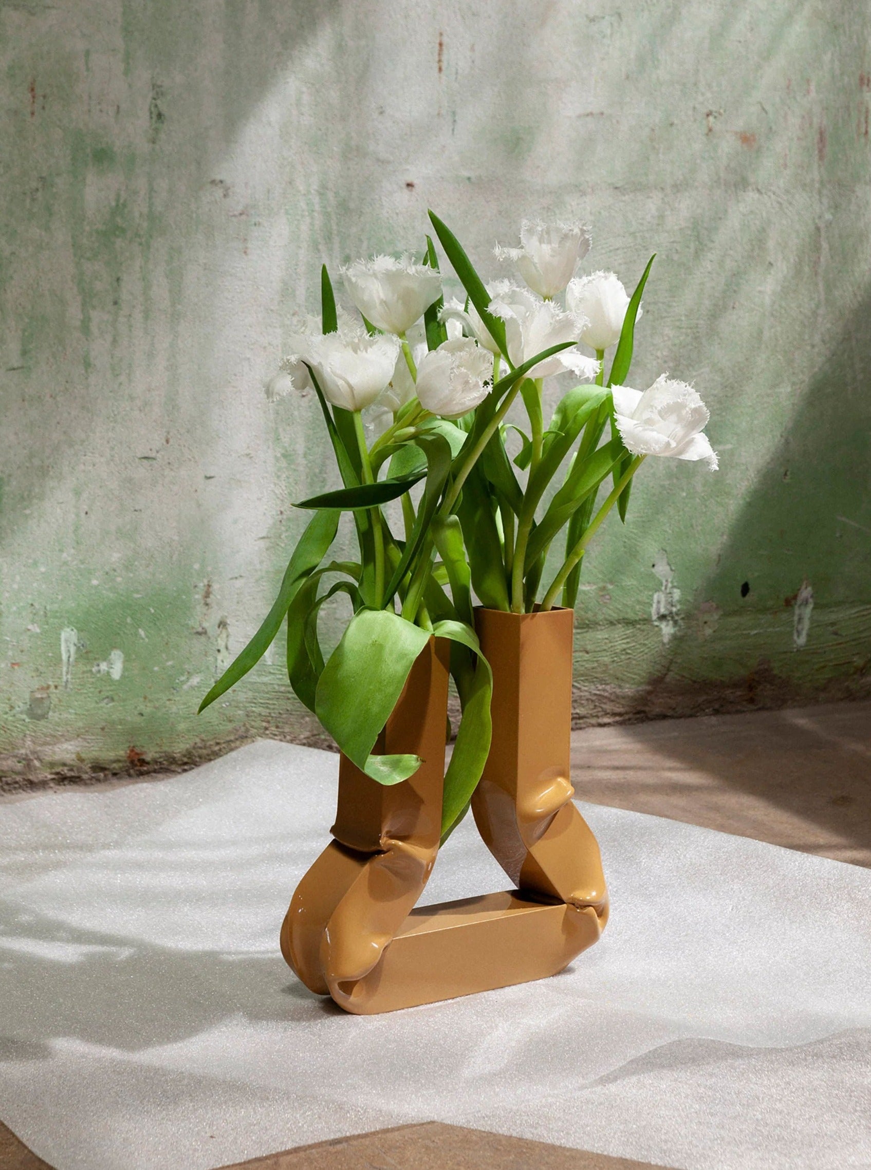 Vasi Vase (Caramel) sitting on a wooden table next to a window with natural light