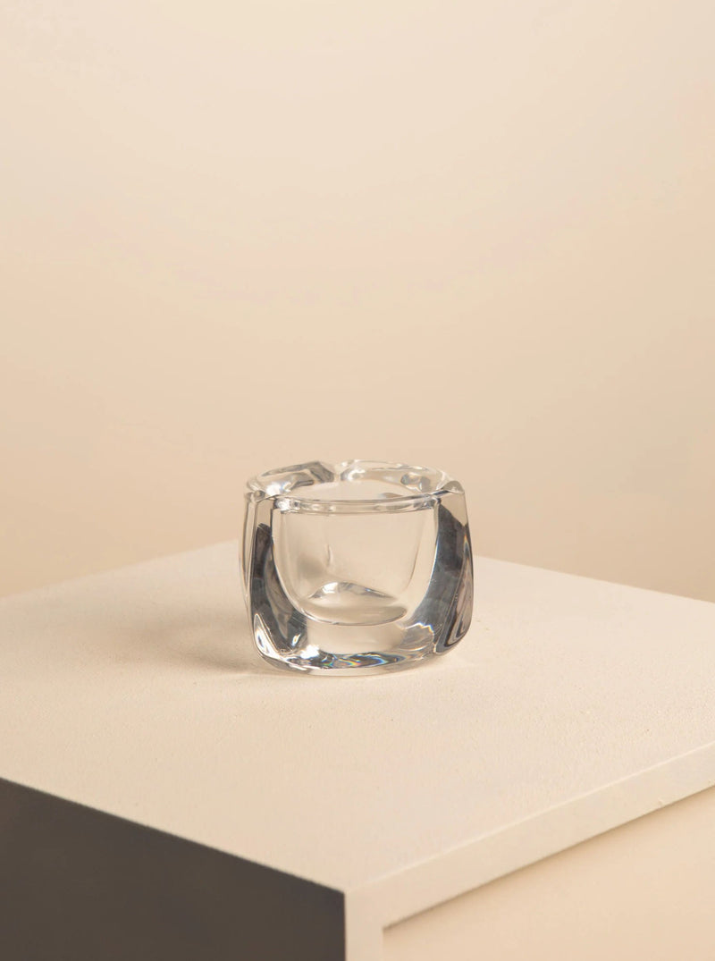 A Crystal Ashtray by Daum 60's placed on a grey plinth against a cream-colored background, highlighting the clean lines and transparency of the object.