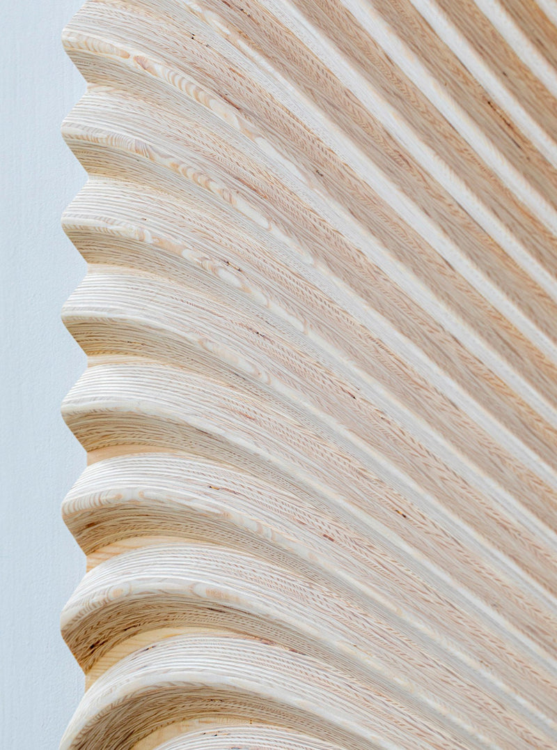 Close-up of Studio Arno Hoogland's "Wave Naturel," a handcrafted wooden sculpture with smooth, wave-like grooves. The light wood grain stands out against a white background, showcasing its intricate texture and craftsmanship—ideal for luxury interiors.
