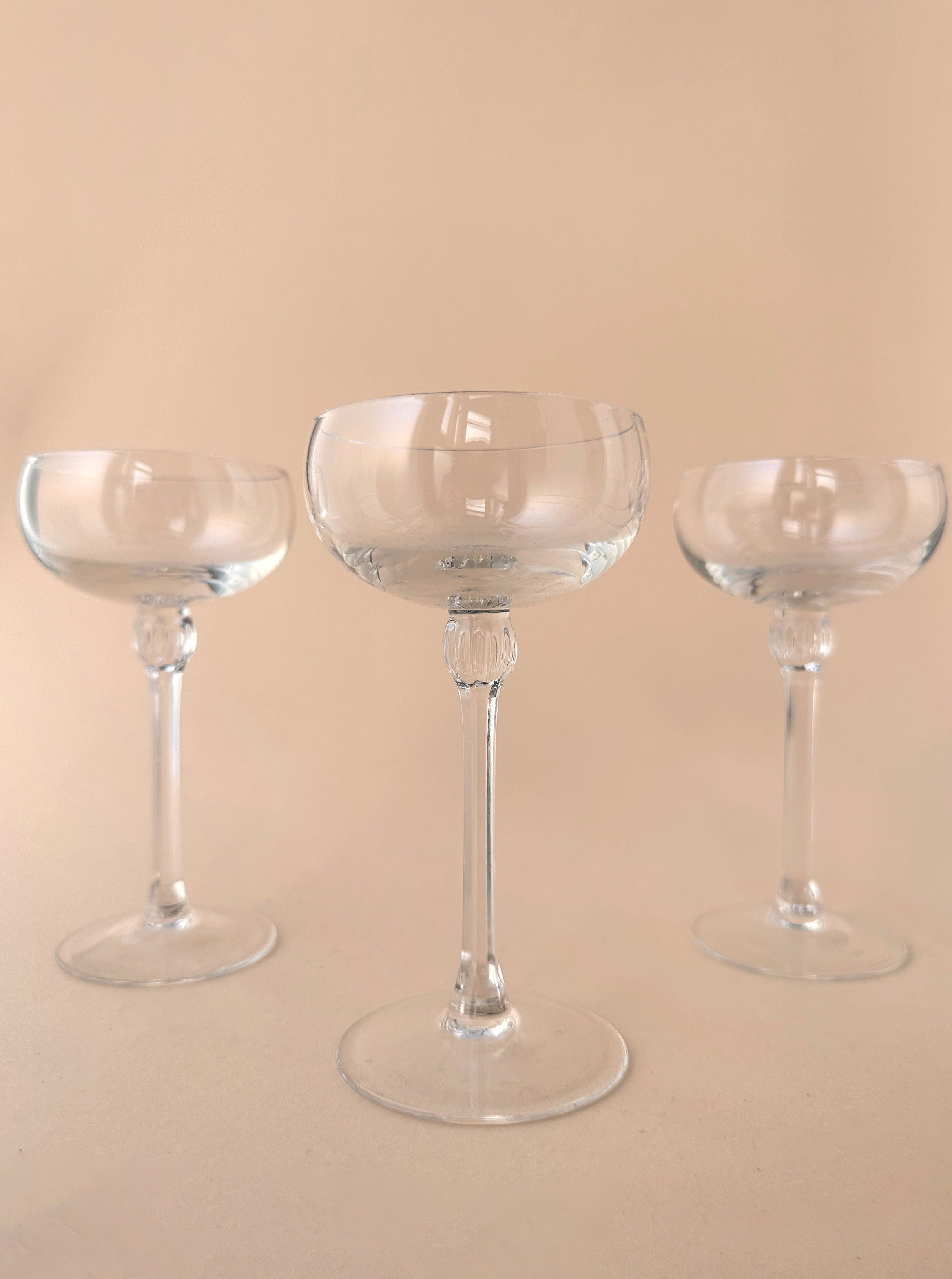  Two images of 5 small champagne bowls, the first one showing the bowls stacked neatly and the second one showing the bowls arranged in a line on a table