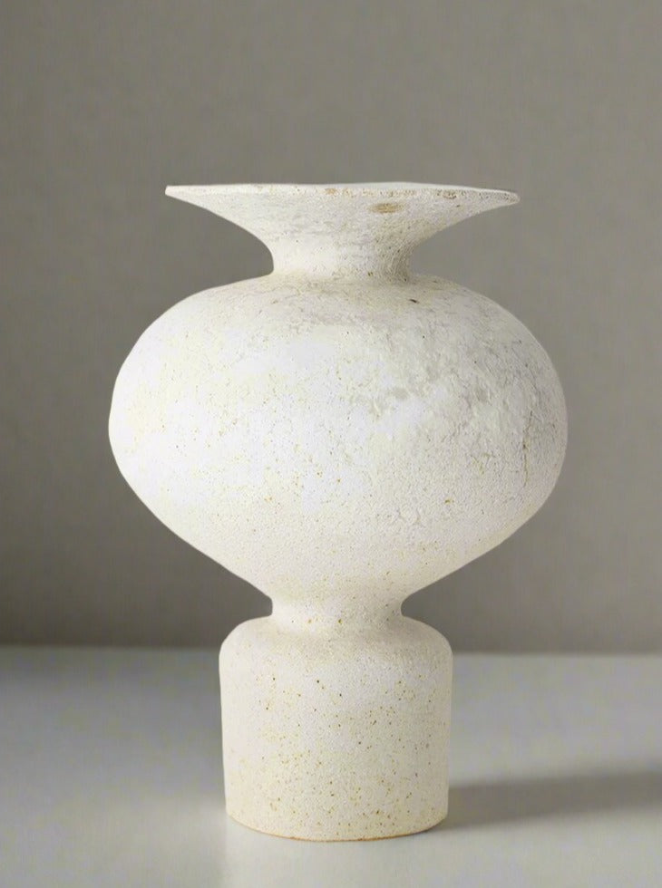 A Isolated n.11 Vase with a unique three-part design featuring a bulbous middle, a narrower cylindrical base, and a flared top, all in a speckled beige color against a white background by Canoa Lab.