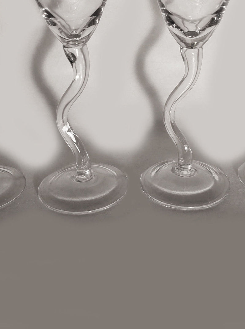 Two Zig Zag Champagne Flutes with elegant twisted stems in monochrome, creating shadows and reflections on the surface below. (Les Objoies)