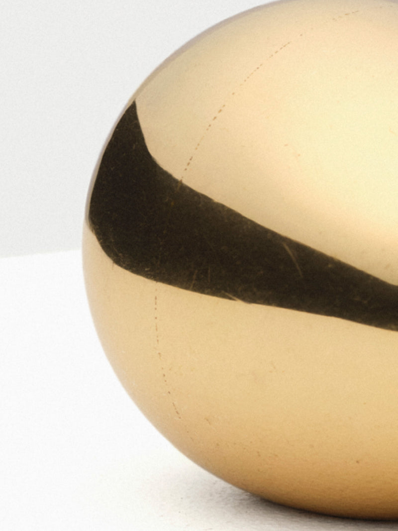 Heavy brass paperweight in the shape of an egg with a polished finish