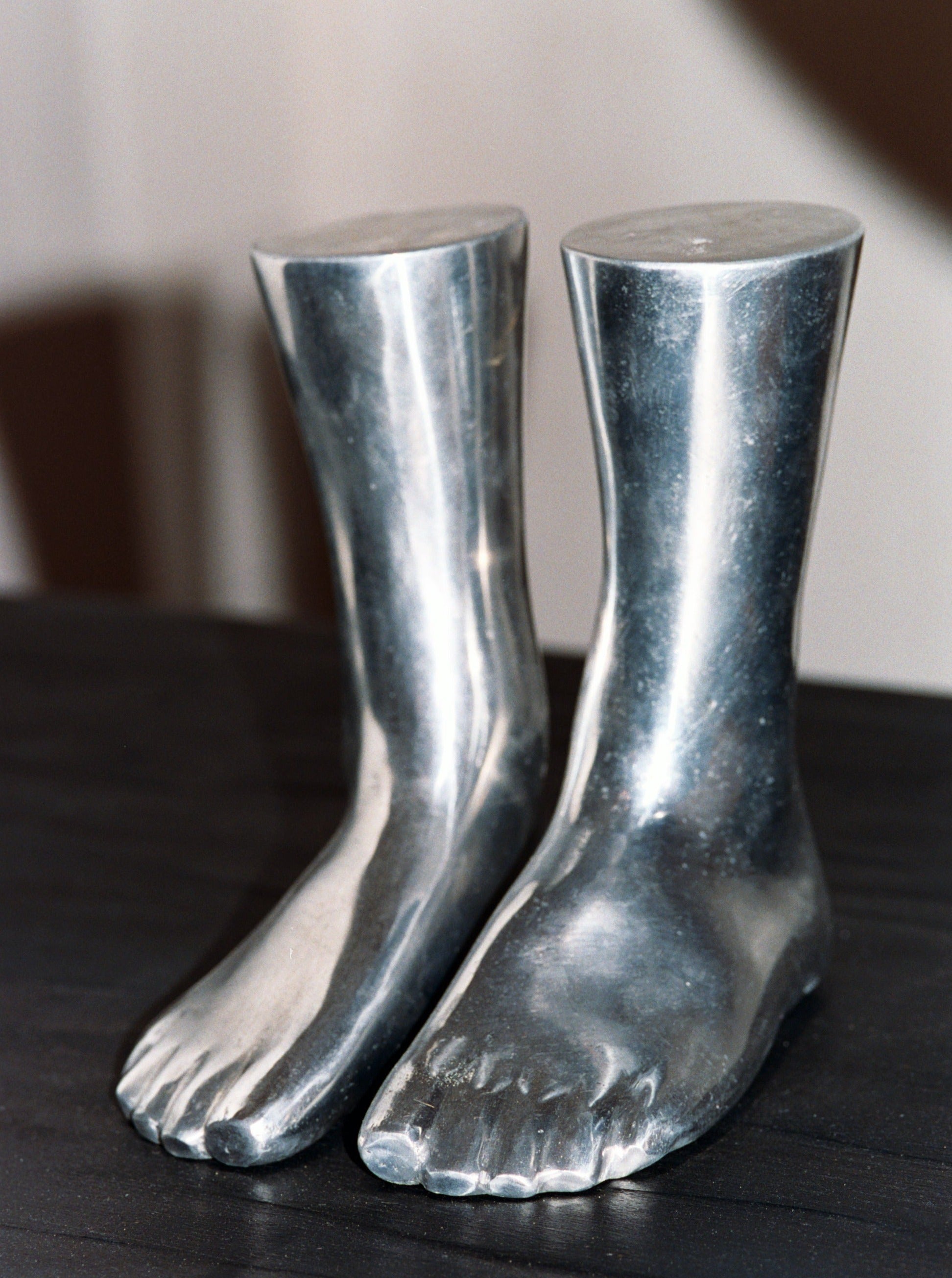 Abstract aluminum sculpture depicting a pair of stylish human feet