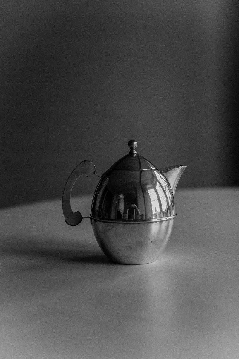 Vintage Art Deco teapot with intricate floral motifs and silver handle