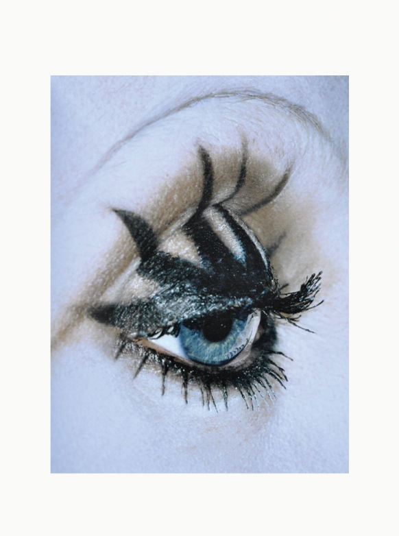 Close-up of a woman's eye with dramatic black eyeliner and mascara, highlighting her blue eye and long eyelashes, captured by art enthusiast Maison Plage - Eyes.