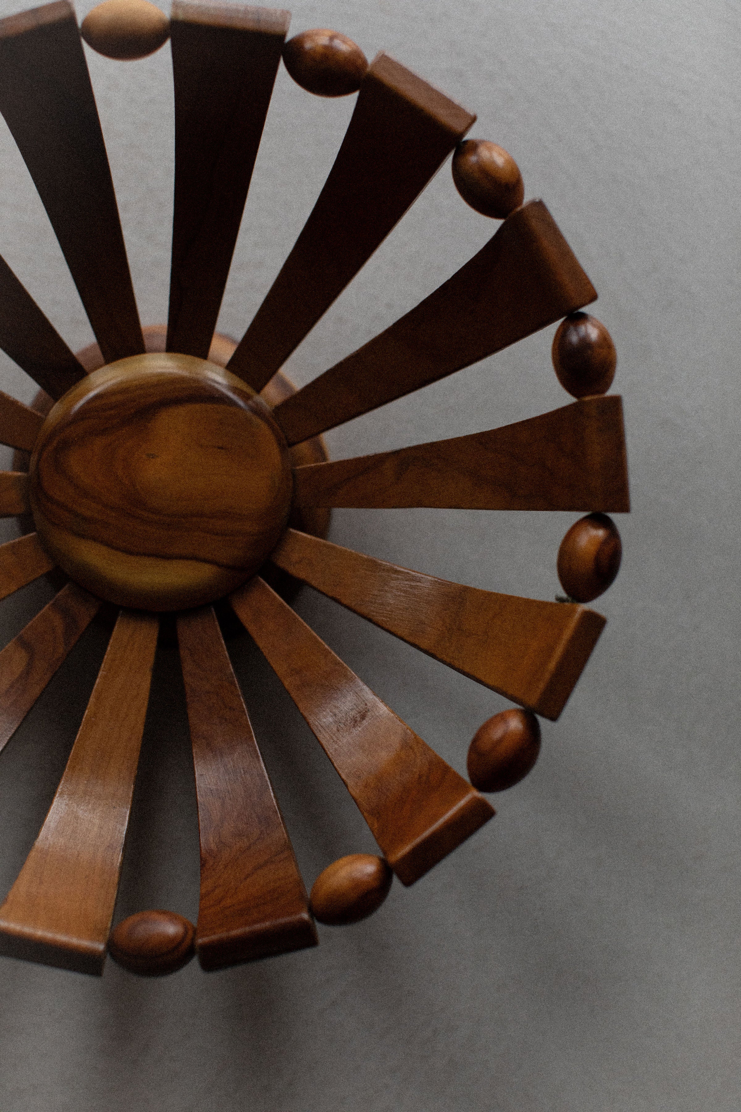 Out For Lunch's 1950's Art Deco Bowl, with a wooden sunburst design, natural grain spherical center and radiating slats each tipped with a ball, is displayed against a muted gray background.