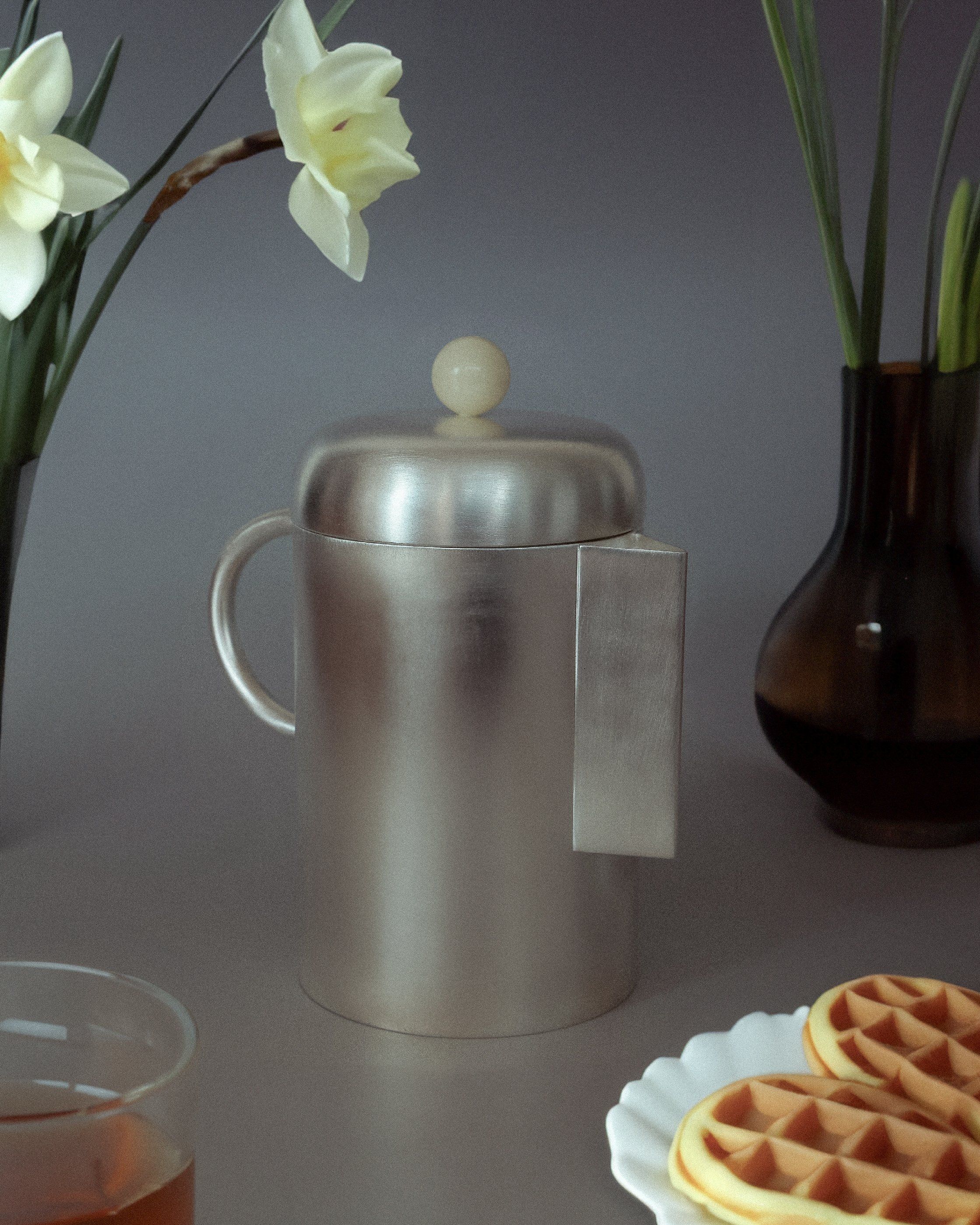 Close-up of a simple white coffee mug filled with steaming hot coffee on a wooden table