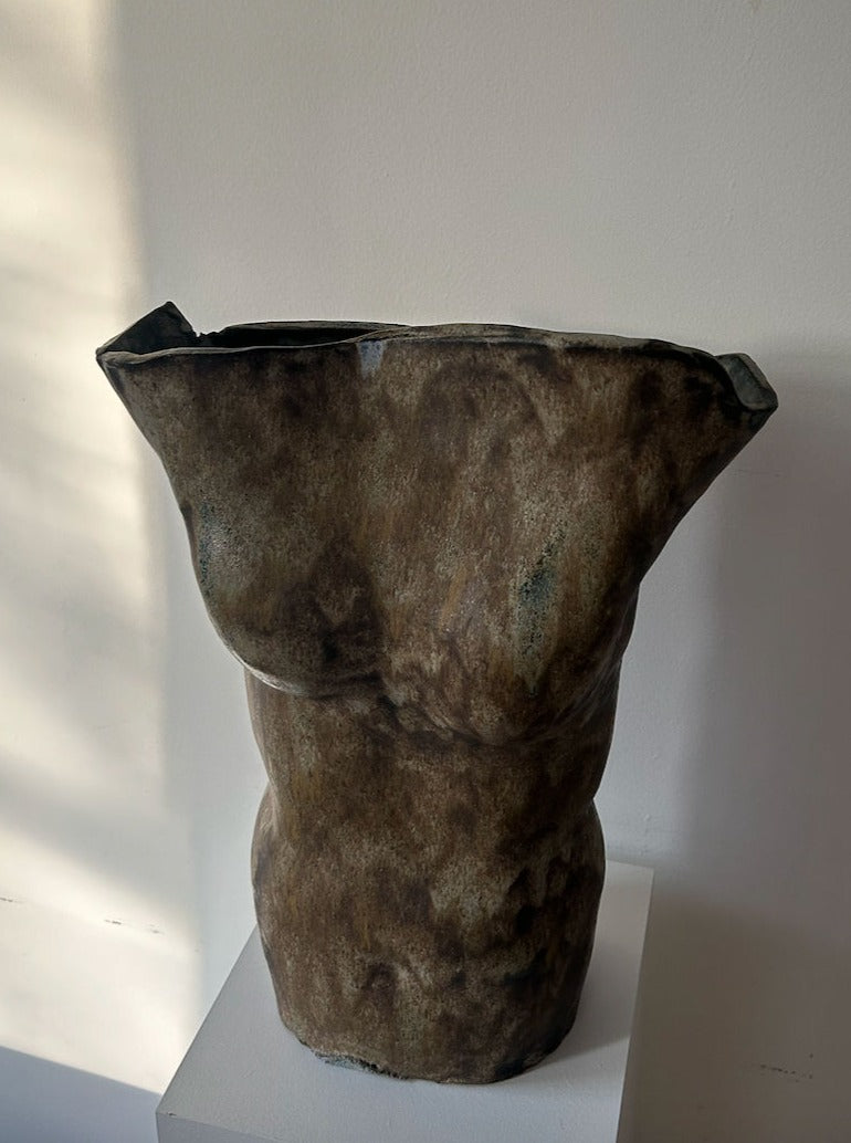 A large, vintage-inspired ceramic torso vase in a rustic finish