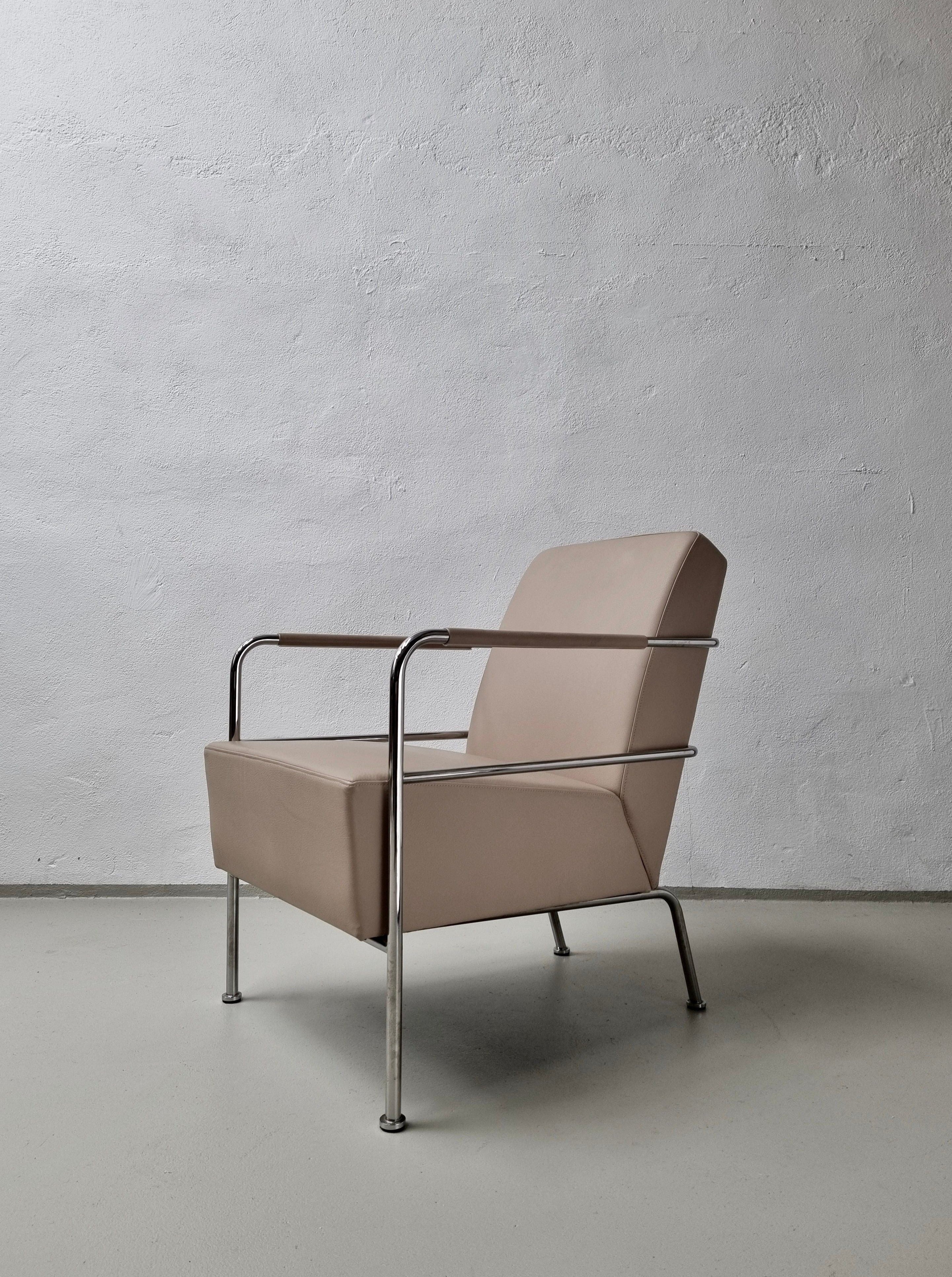 A minimalist beige high-quality leather chair by Gunilla Allard for Lammhults 1990s with a metal frame against a textured white wall in a stark, well-lit space.