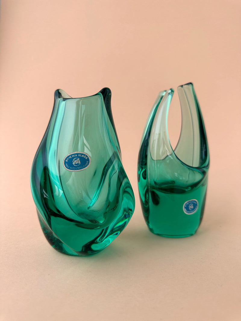 Two elegant Vase + Basket Bowls in Turquoise By Miroslav Klinger with a wrinkled design on a pale pink background. Each vase has a sticker indicating they are from Dodo Vintage Bohemia Glass Czechoslovakia.