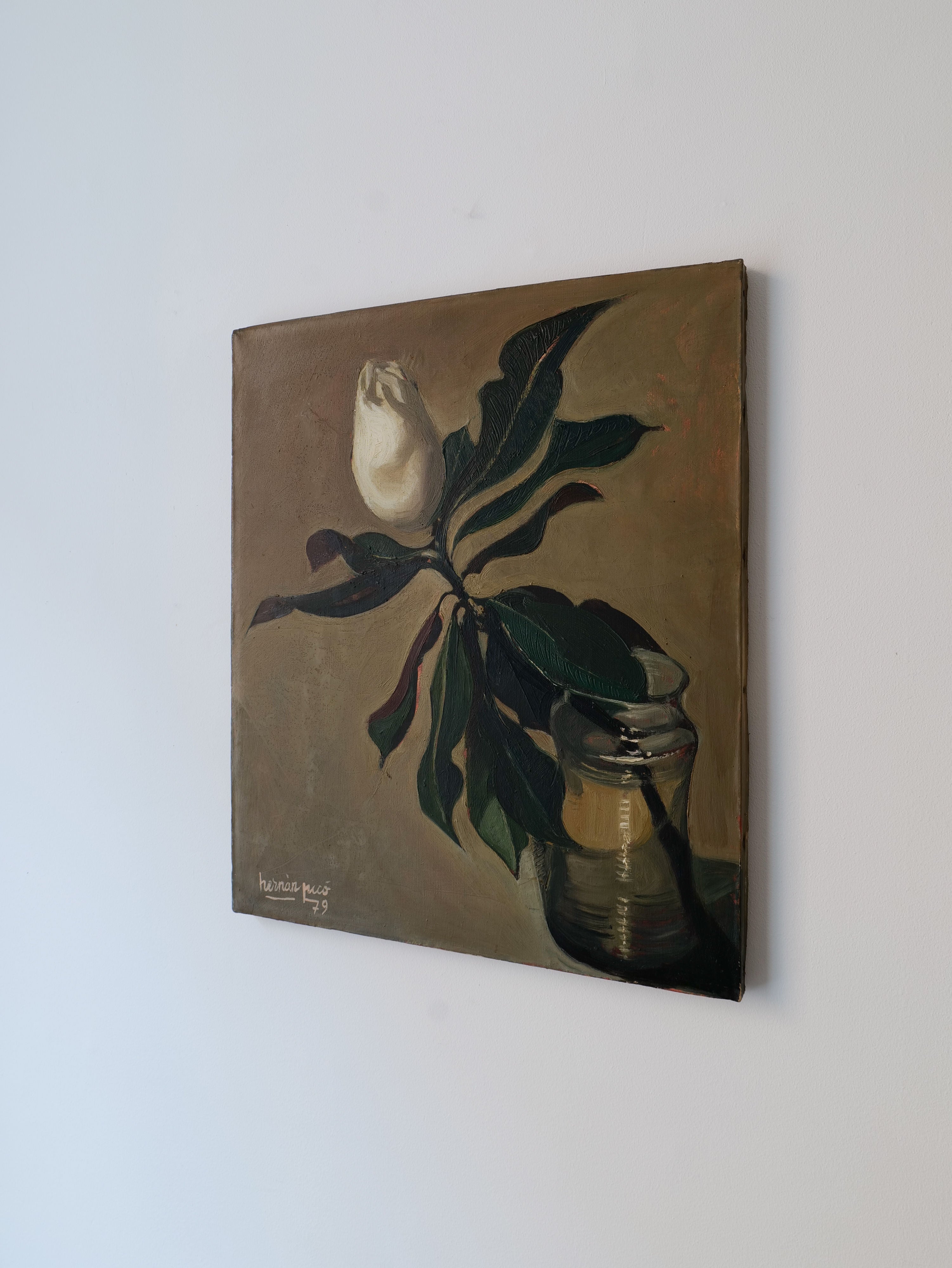 Oil painting on a canvas of a Magnolia Grandiflora 1979 stem in a glass jar, with bold green leaves, highlighted against a subdued background, hanging on a white wall by Collection apart.