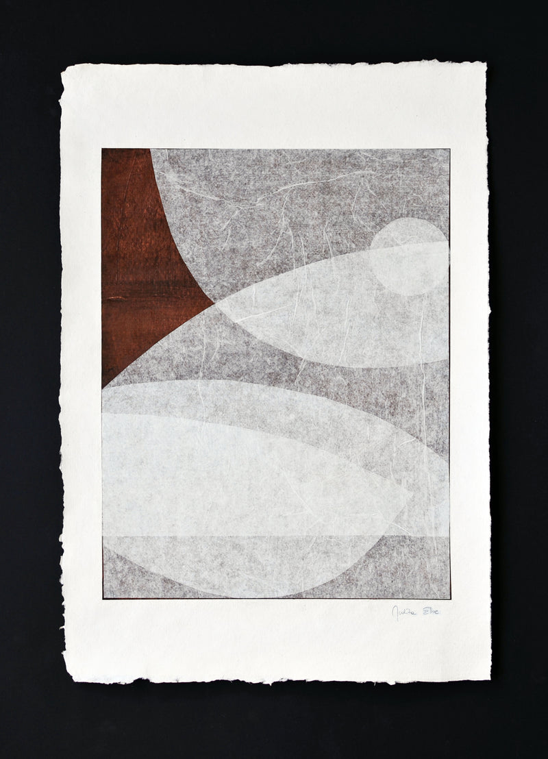 The abstract artwork "Moment" by Julita Elbe features large leaf-like shapes in grey, brown, and white on textured paper with rough edges. Set against a black background, it enhances luxury interiors or pairs elegantly with collectible furniture pieces.