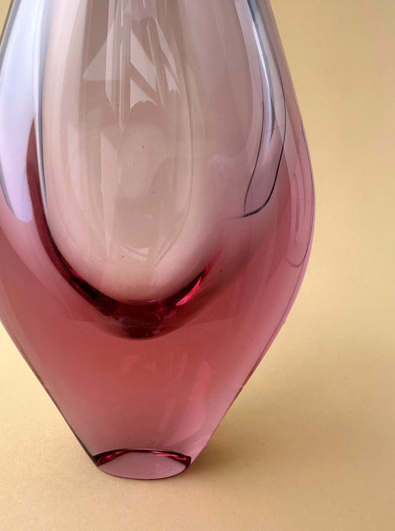 Close-up of a pink Bohemian Alexandrite / Neodymium Glass Vase by Miroslav Klinger for ZBS, with soft reflections and curved lines, set against a beige background.