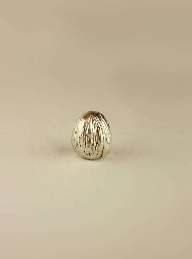 Handcrafted silver walnut sculpture with intricate carved details and polished finish