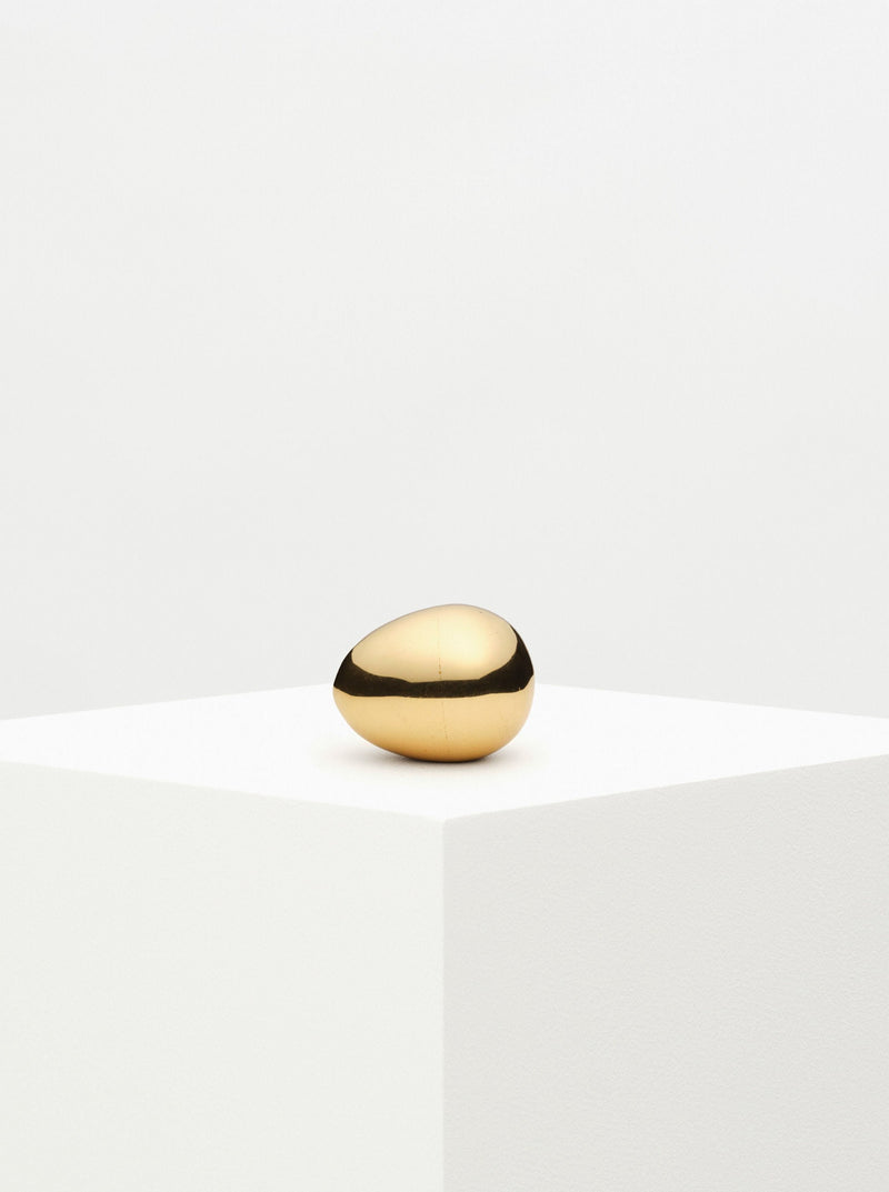Brass egg-shaped paperweight with intricate engraved floral design