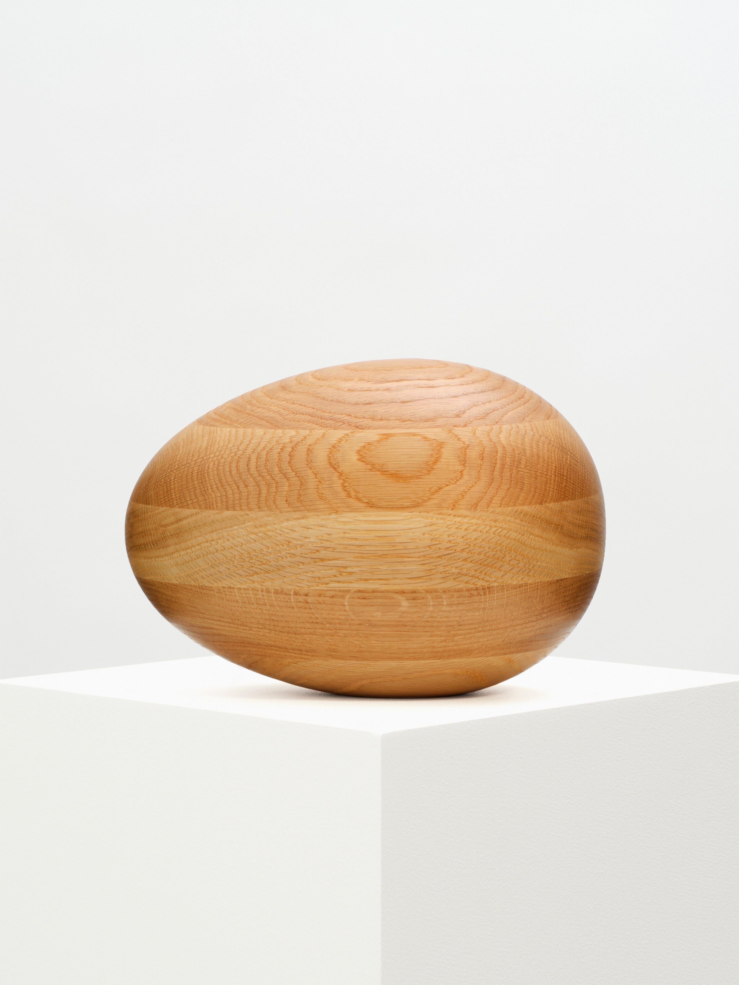  Close-up image of a Natural Oak Egg Sculpture, showcasing the beautiful and intricate wood grain and natural finish, ideal for home decor and gifting