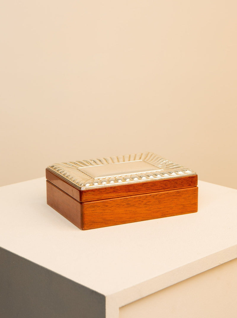 A Treaptyque USA 80's Rectangular Wooden Box with an intricate pearl inlay on the lid, placed on a gray surface against a soft beige background.