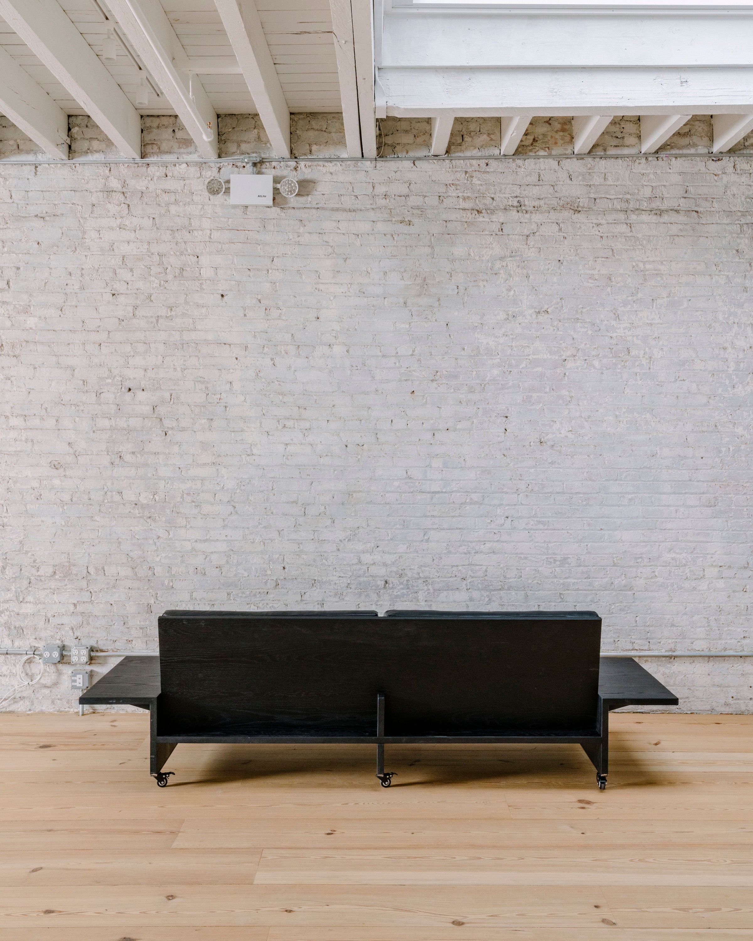 Spacious and modern Domino Sofa with adjustable headrests in black leather