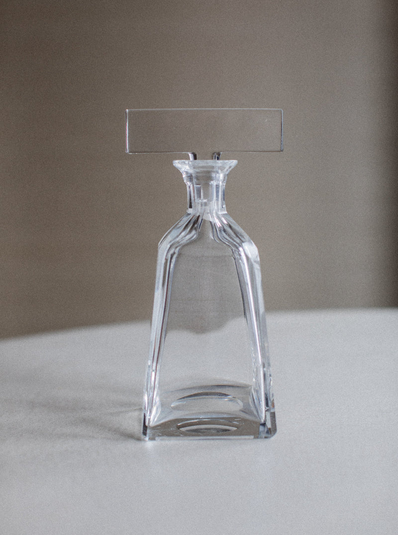 Tall and slender glass decanter with a graceful curved spout