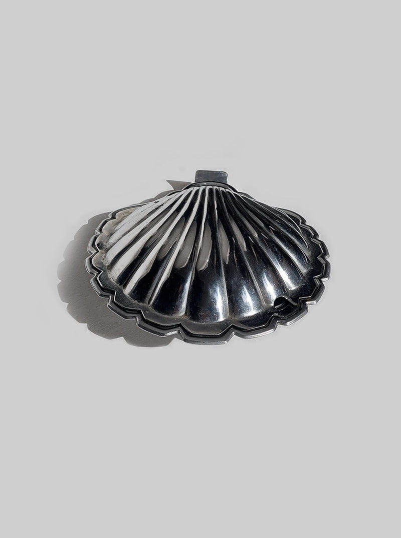 White porcelain butter dish in the shape of a scallop shell