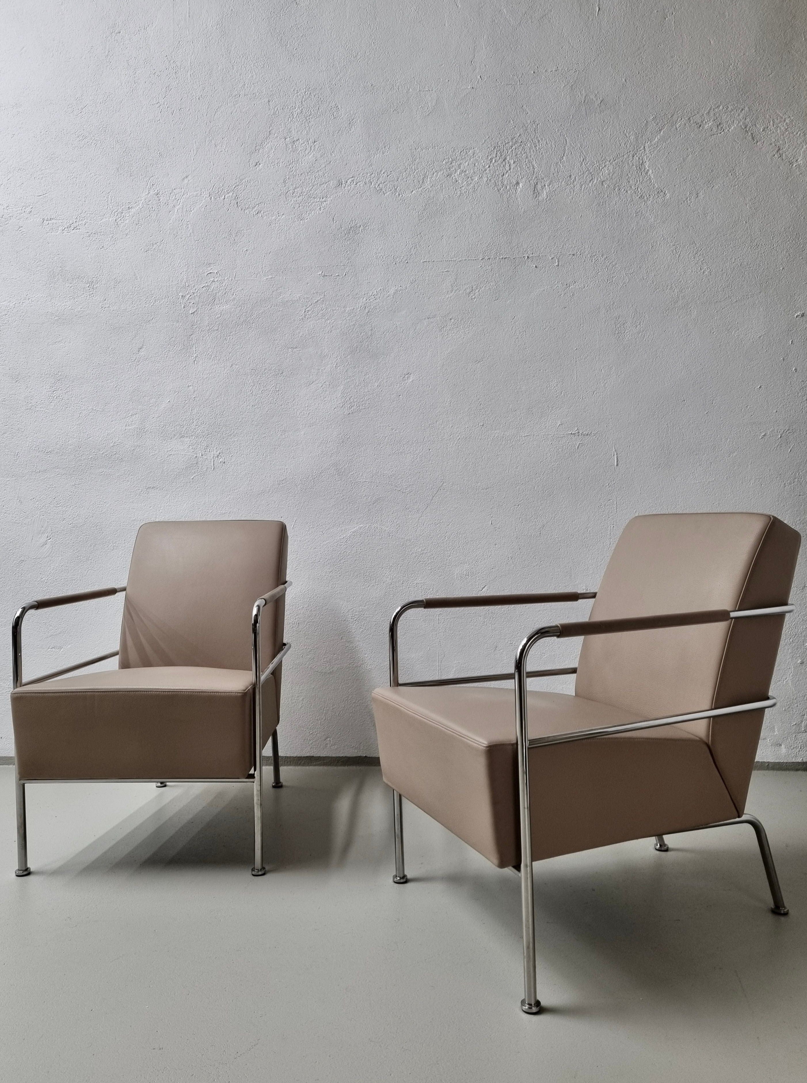 Two modern Veter Vintage chairs by Gunilla Allard for Lammhults 1990s with sleek metal frames positioned on a grey concrete floor against a textured white wall, creating a minimalist look.