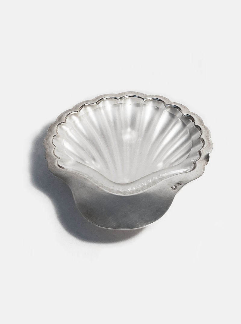 A ceramic butter dish with a delicate shell-shaped design and lid